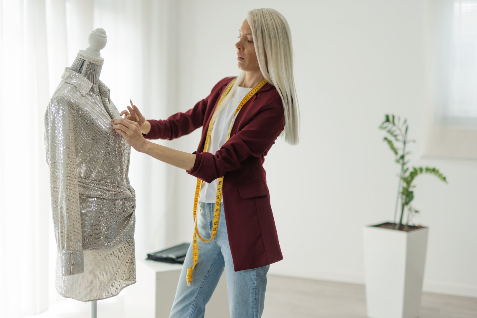 Female fashion designer tailors sparkly silver dress