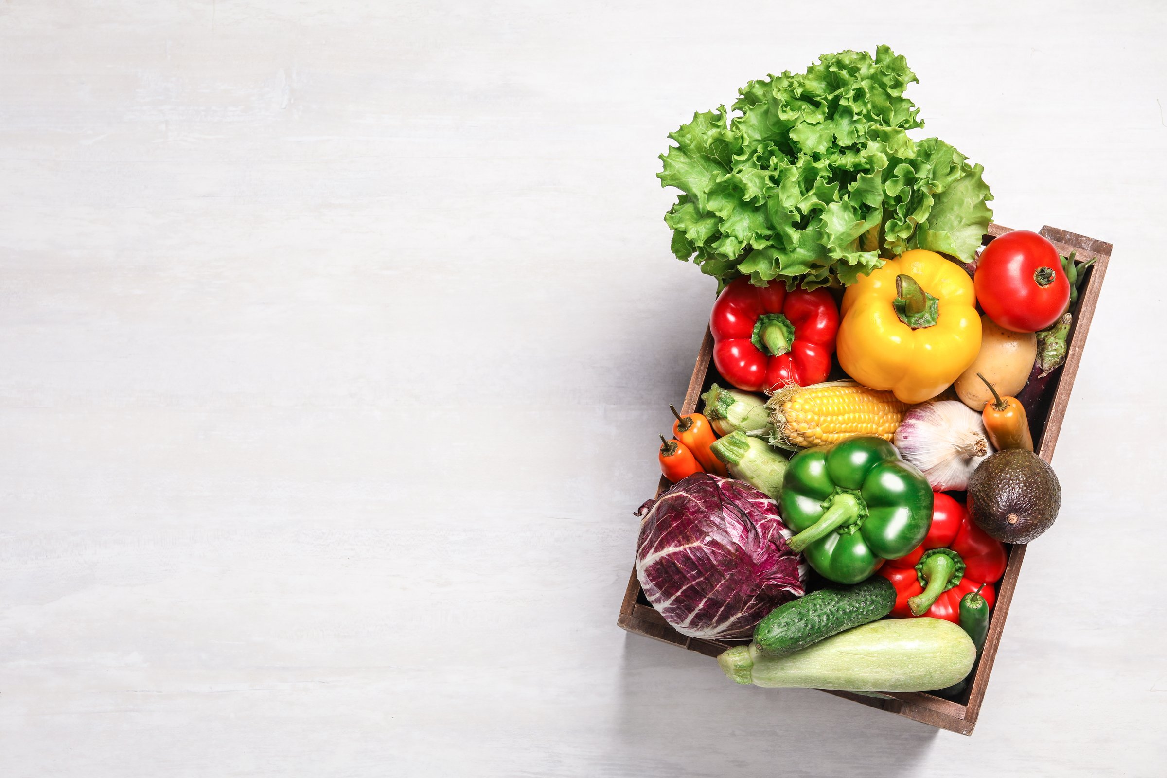 Fresh Vegetables in Wooden Crate on White Background.
