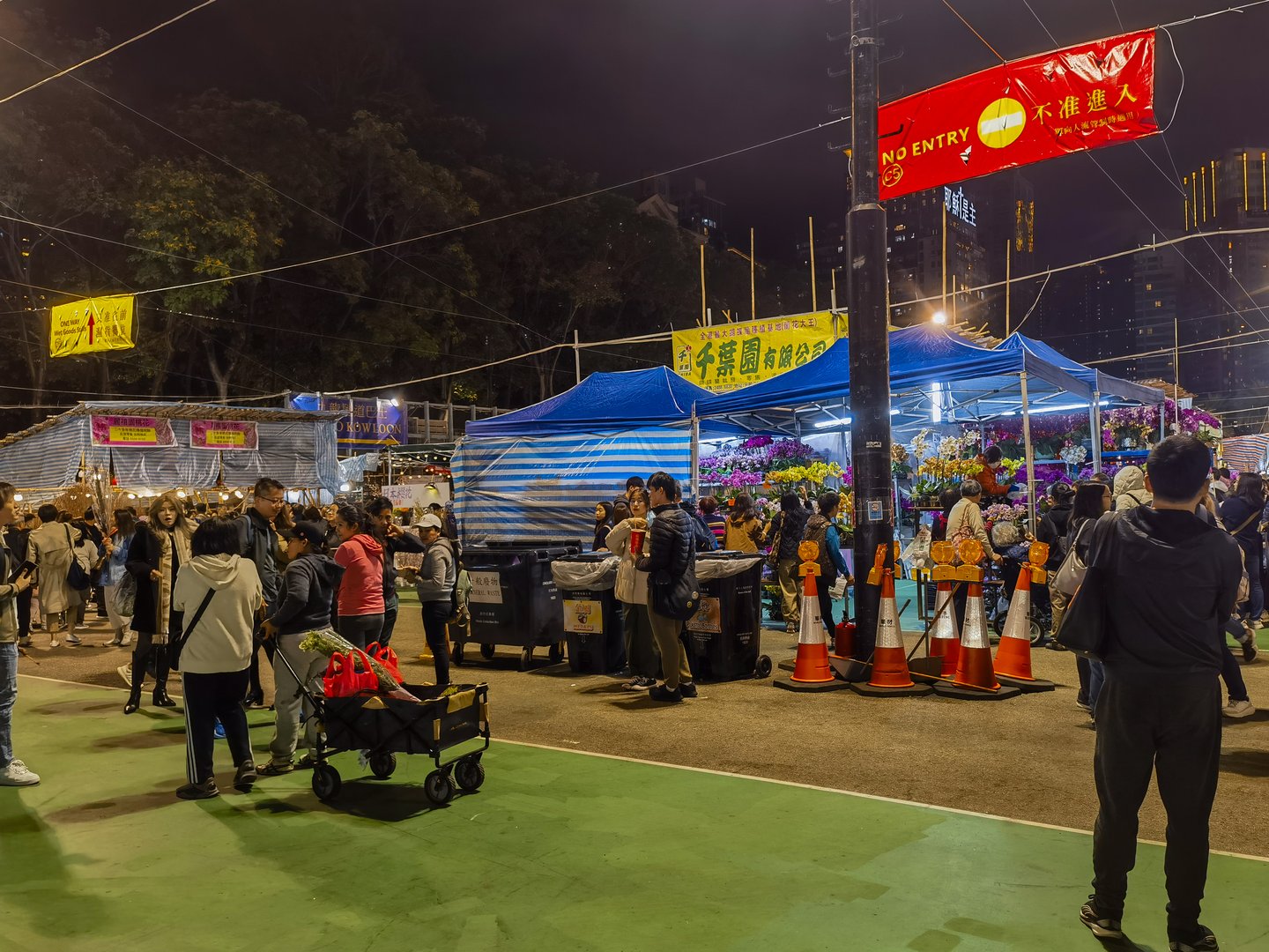HongKong, China - January 24, 2025 : Night scene at a bustling Chinese New Year Fair in 2025.  Crowds gather around market stalls, illuminated under temporary lighting. Festive atmosphere is evident.