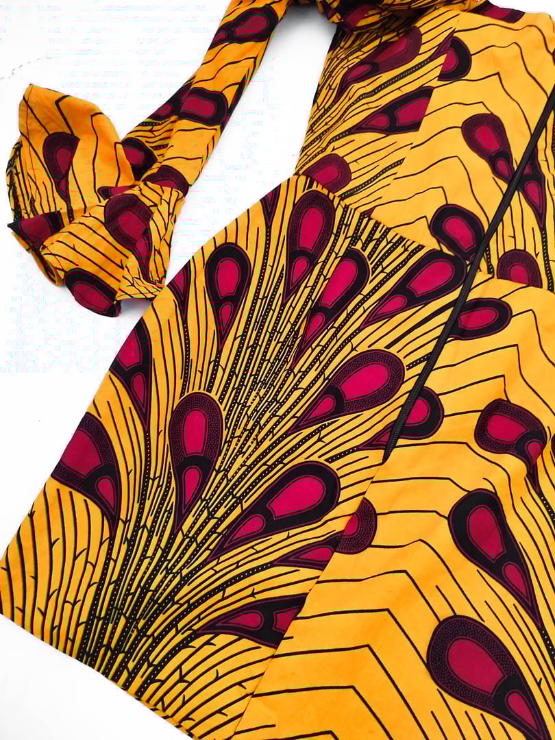 African patterned runya occasion dress details, yellow cotton long puffy sleeve dress with red paisley print at white background flat lay, clothes, apparel, fabric, clothing store, manufacturing