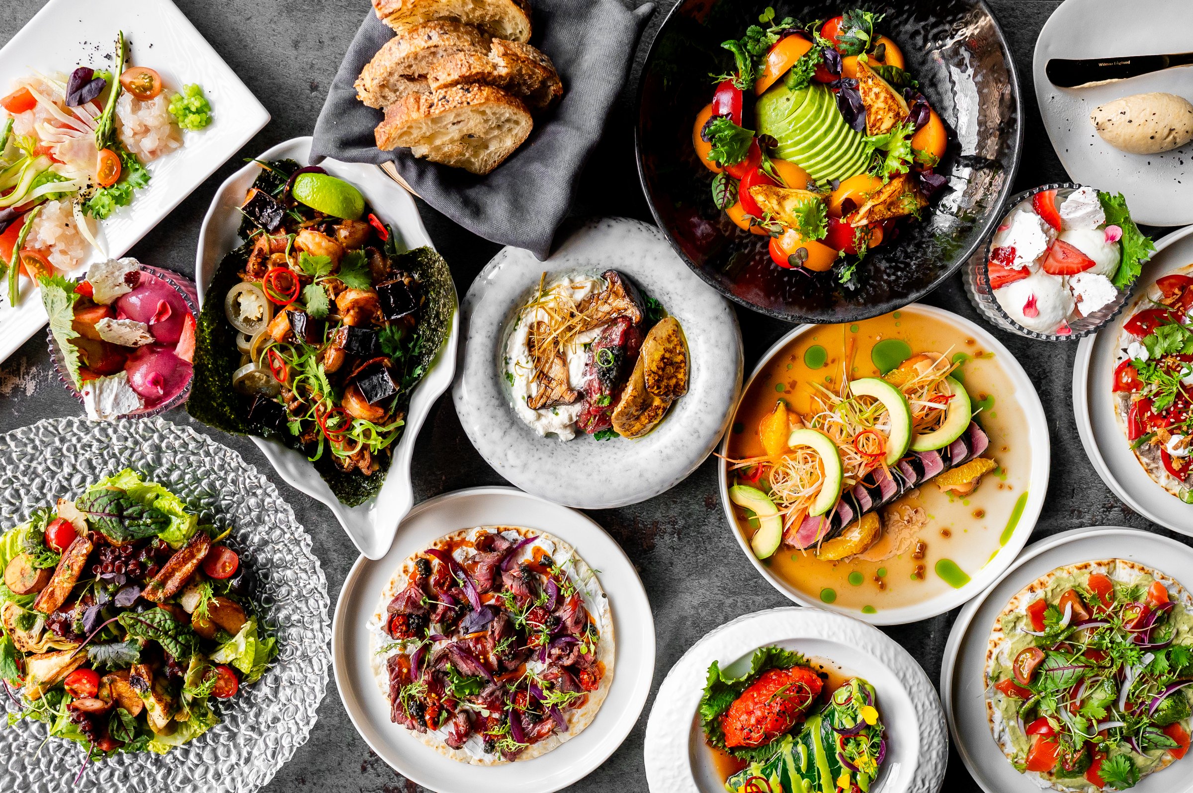 Variety of gourmet dishes displayed on a table, showcasing an array of colors and textures, ideal for culinary