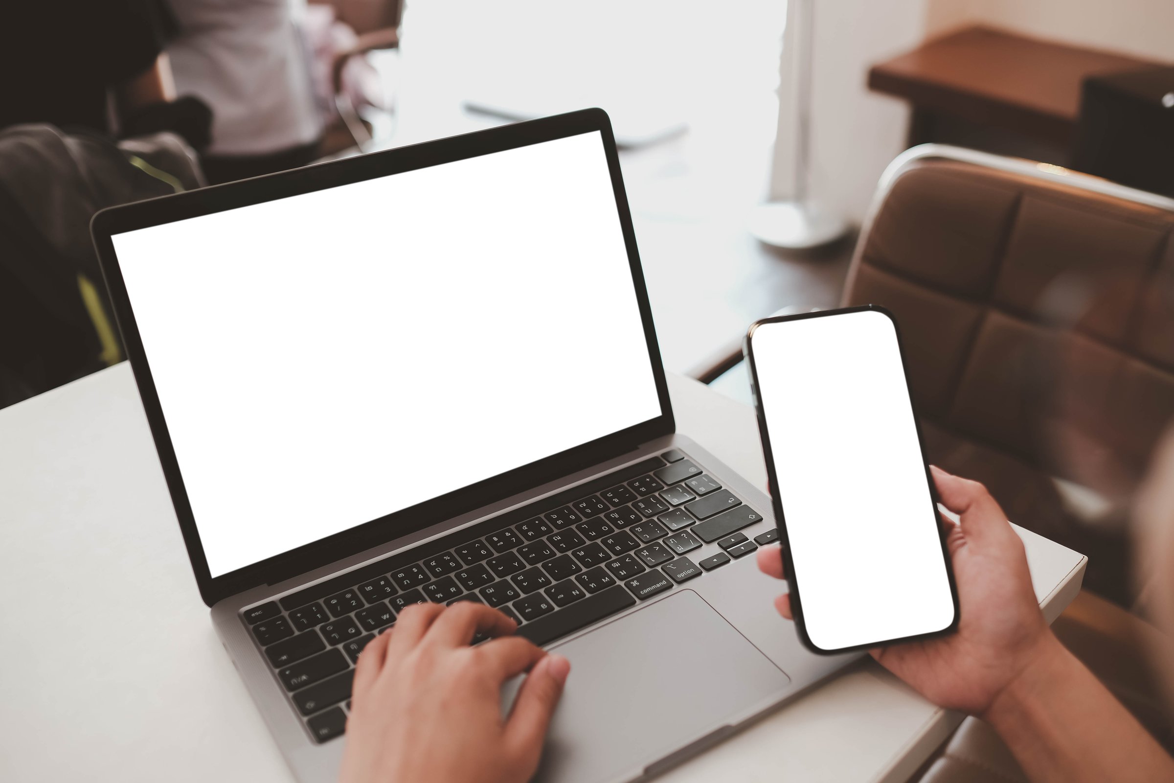 Close-up image of a woman sitting in the cafe and using her smartphone and laptop. smartphone and laptop white blank screen mockup for display your graphic banner.