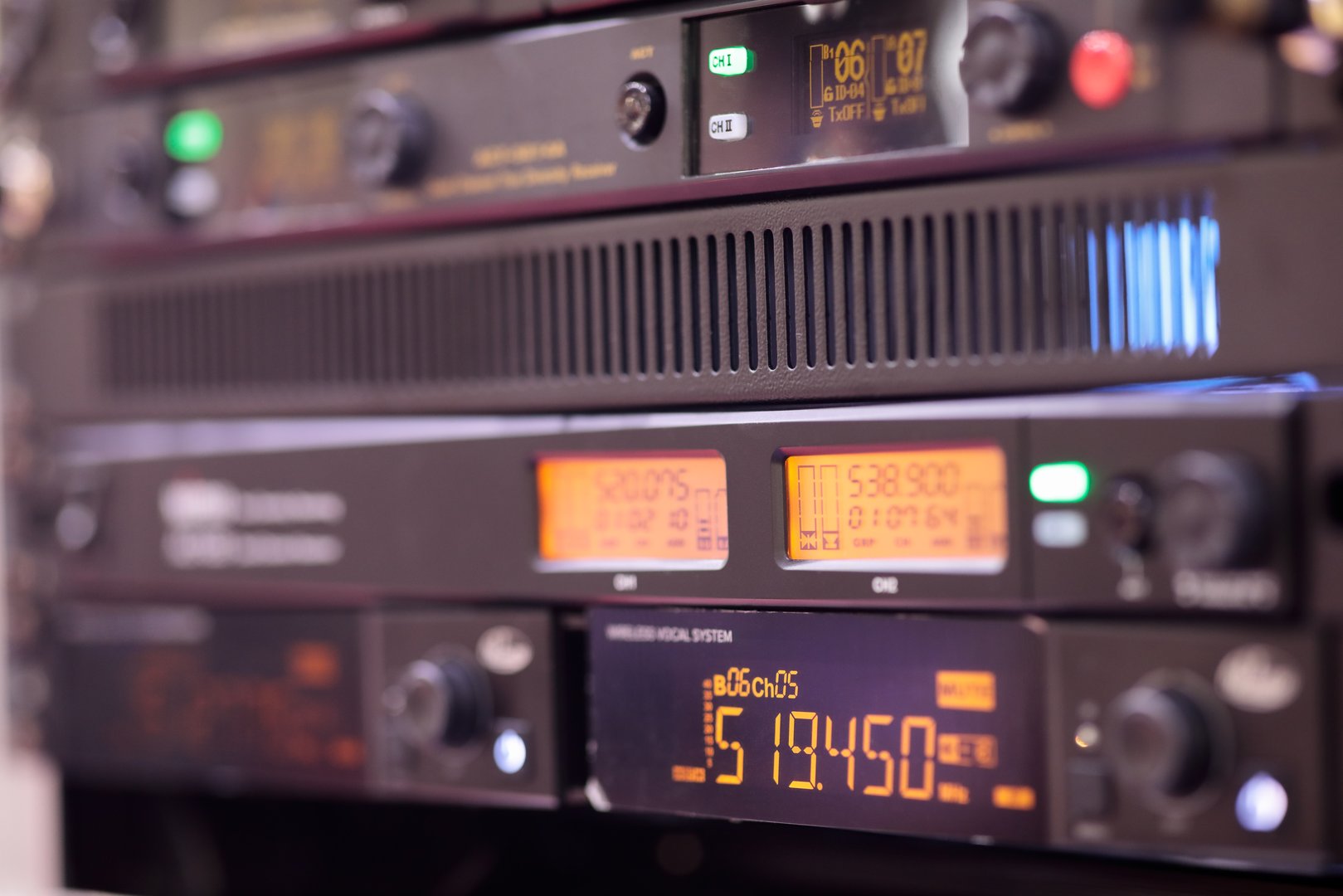Rack mounted digital wireless system with receivers for wireless microphones and other audio equipment. It can be applied in concerts, conferences, karaoke and live streams. Selective focus.