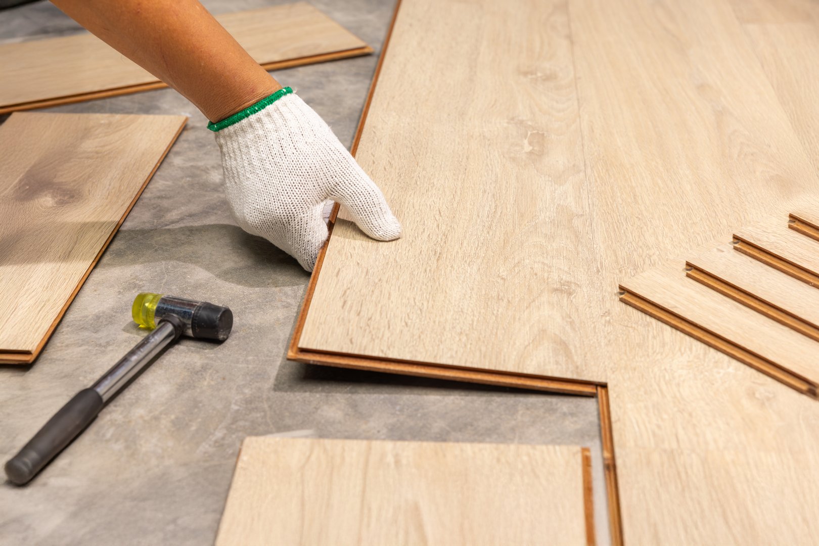 Worker Installing Interlocking laminate floor, home renovation.
