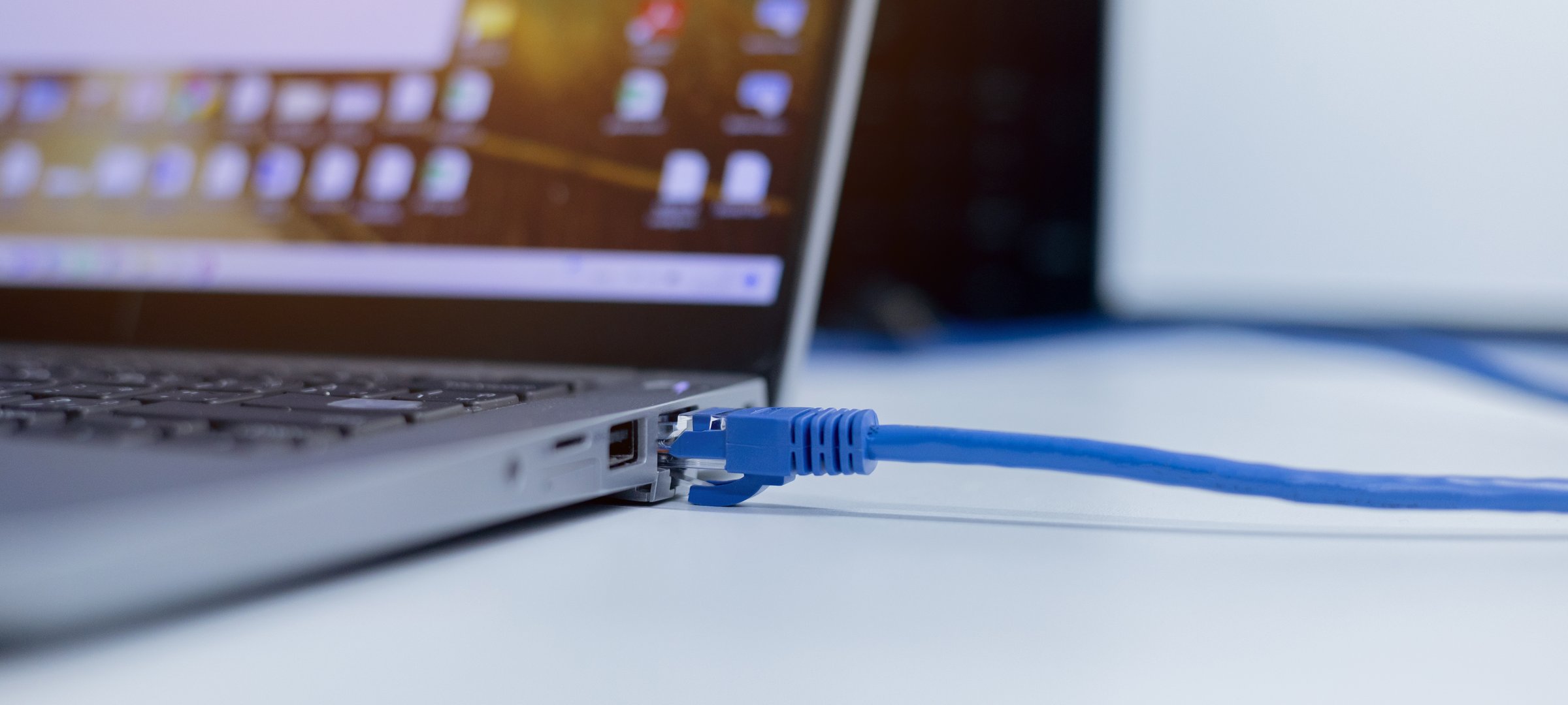 close up on blue RJ-45 Lan cable connect to computer port or laptop to accessing internet network for ethernet and communication technology concept