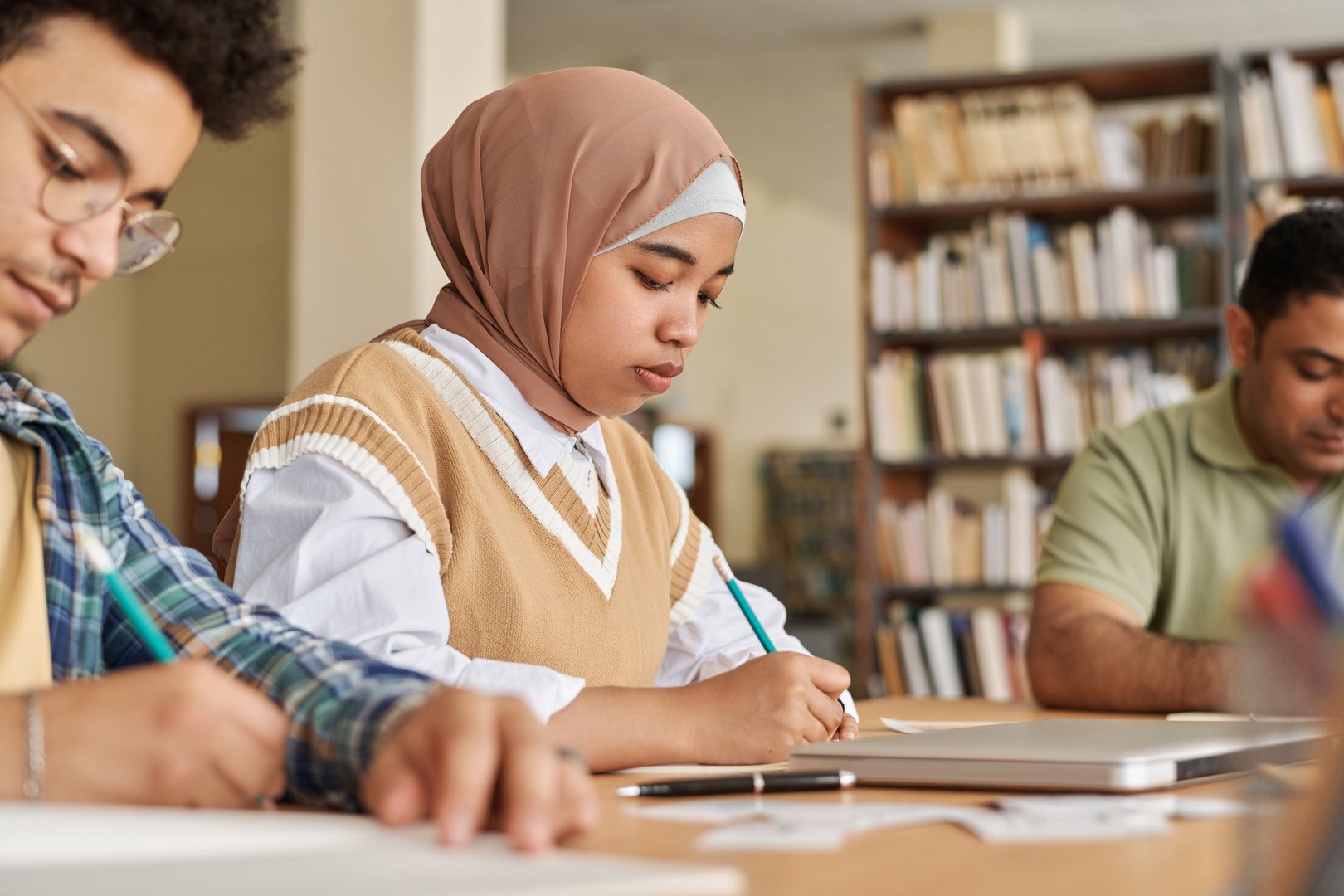 Migrant students passing foreign language exam at table in class