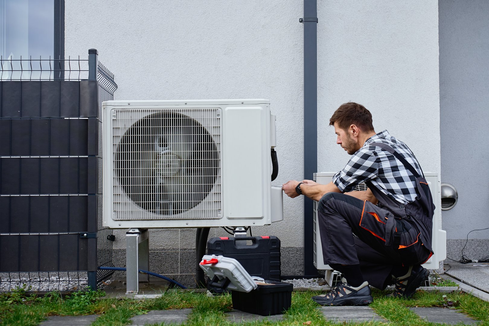 Technician installing air source heat pump unit