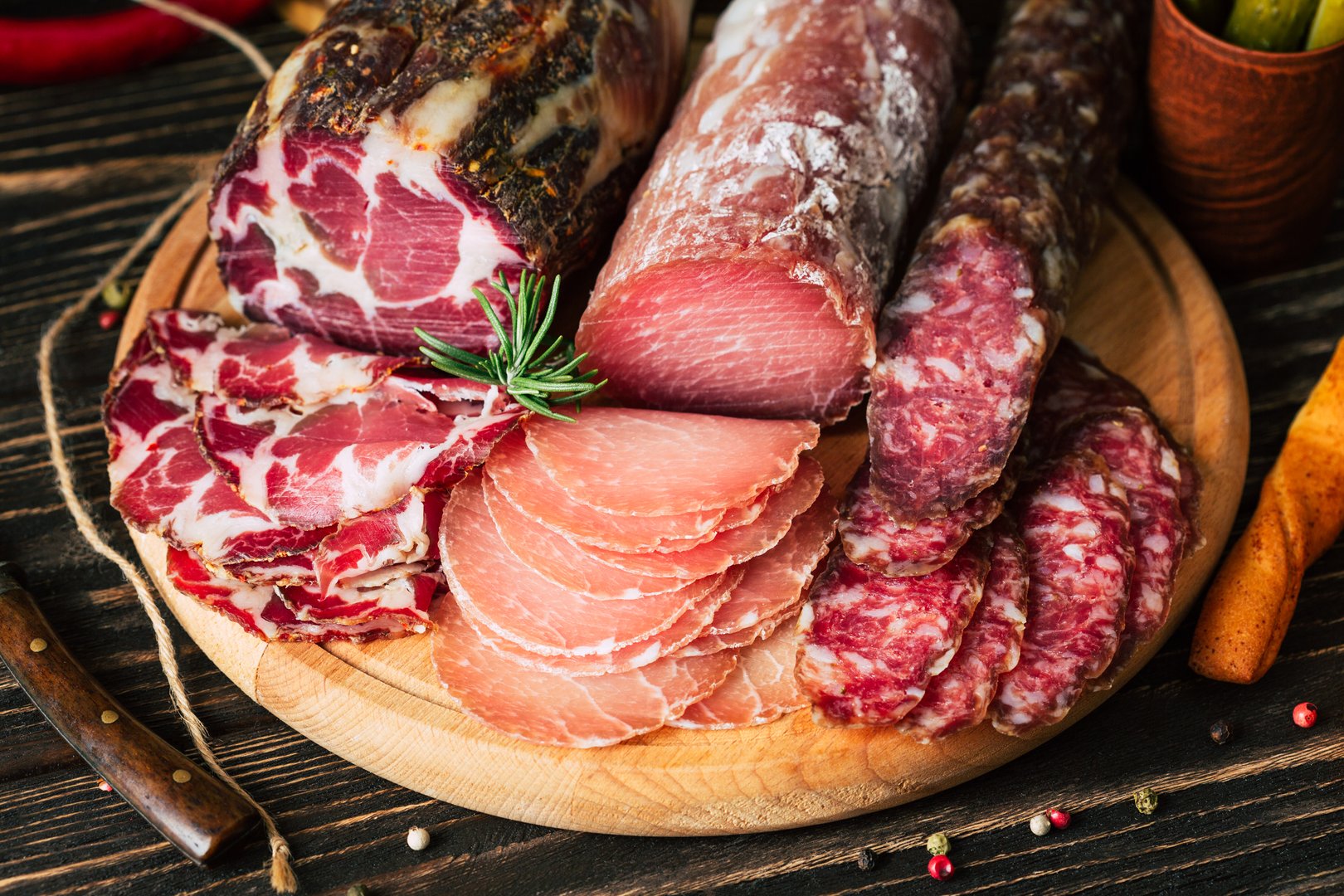 deli meats on a wooden background, dried sausage on a cutting board