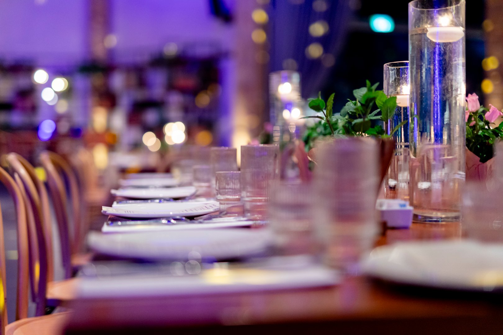 Luxury table settings for fine dining with and glassware, pouring wine to glass. Beautiful blurred background. Preparation for holiday wedding. Fancy luxury restaurant.