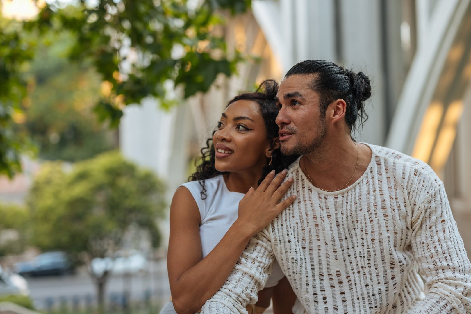Happy couple enjoying a sunny day in Spain, admiring stunning modern architecture while exploring the vibrant city together