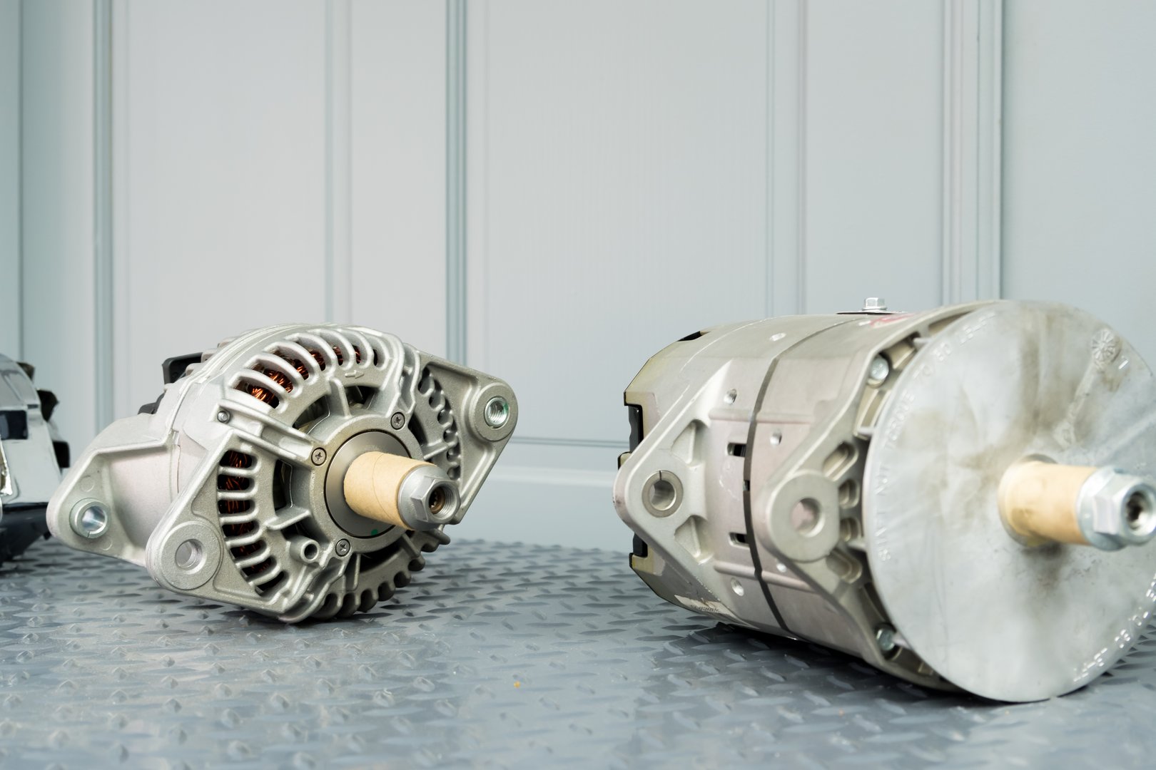 Car alternators on display on metal shelf/auto parts