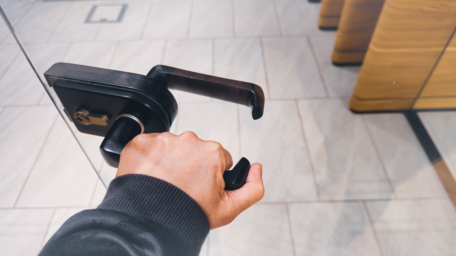 A hand opens the glass door of the meeting room