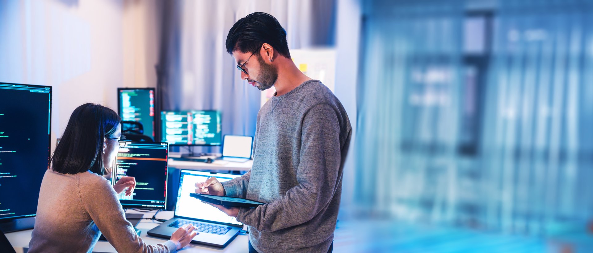 asian and Indian Developer  devops team discussion  about coding promgram with software computer at night in office