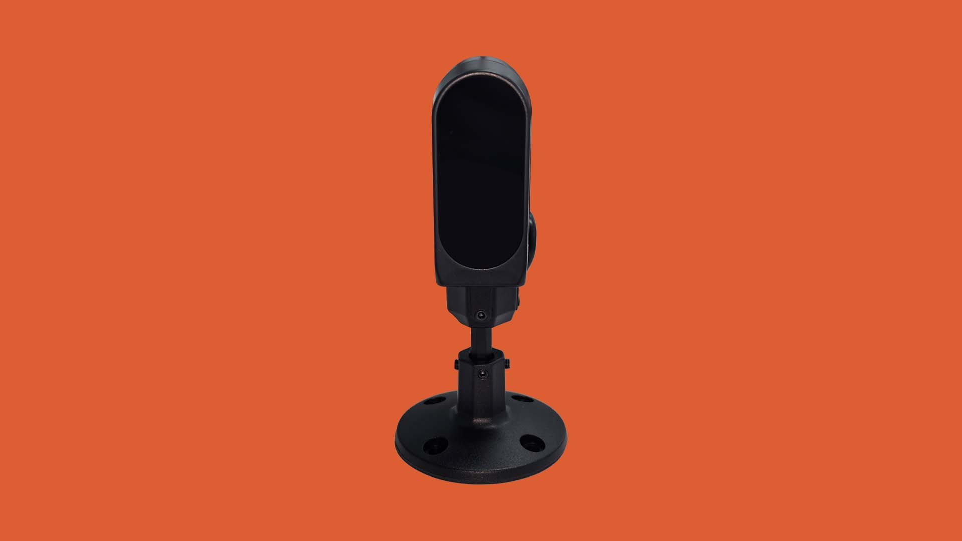 Black security camera mounted on a stand against an orange background.