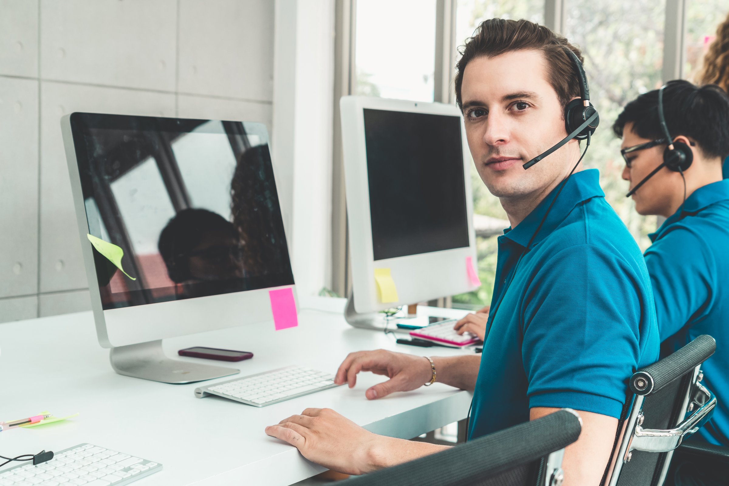 Business people wearing headset working in office to support remote customer or colleague. Call center, telemarketing, customer support agent provide service on telephone video conference call.