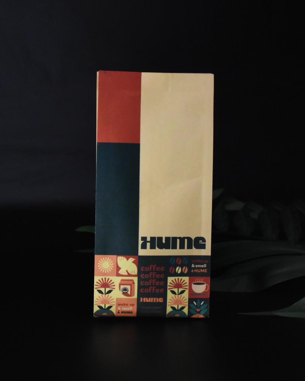 A Hume coffee bag with a colorful design featuring abstract shapes and coffee-themed icons on a black background.