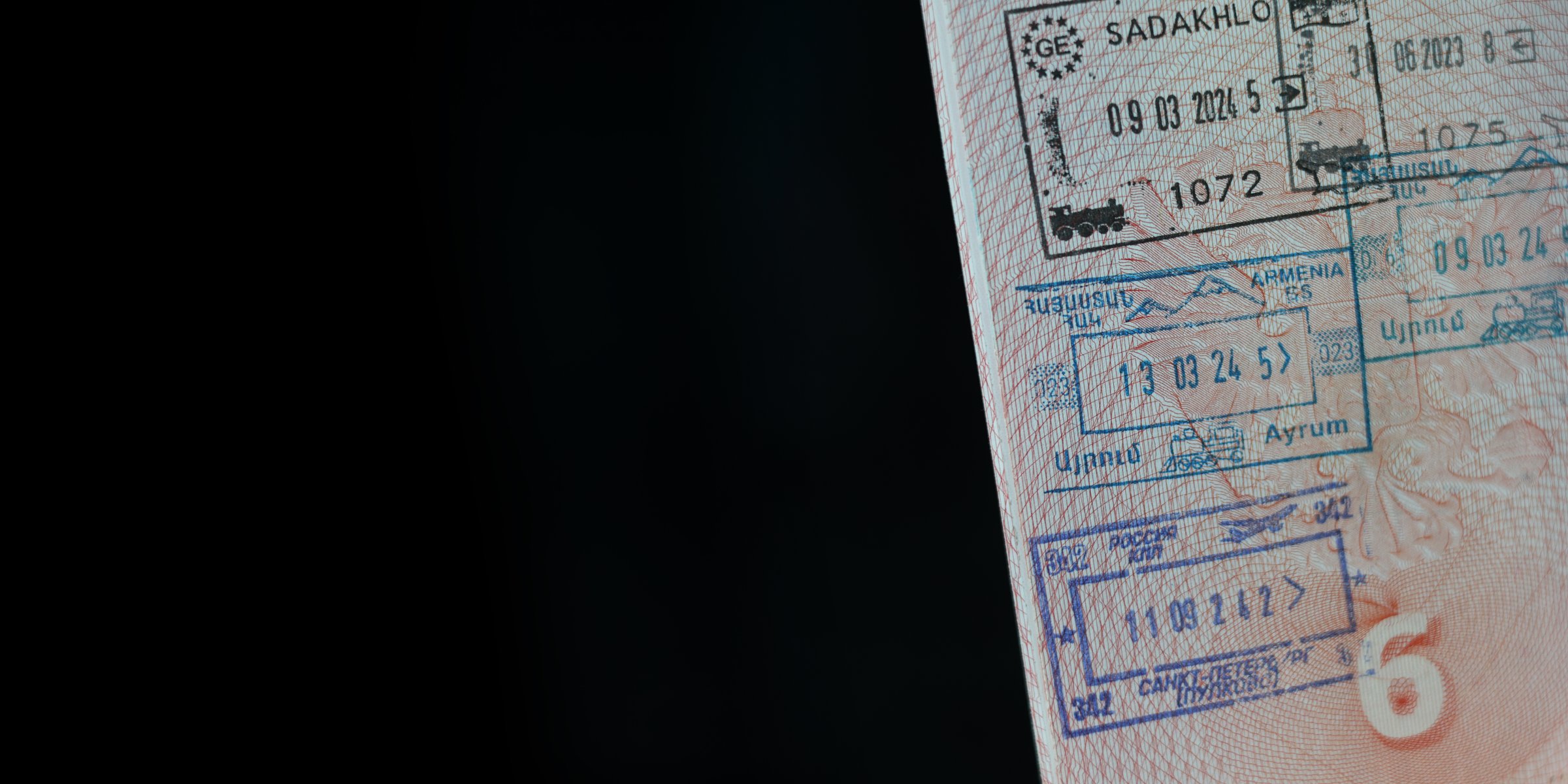 Horizontal banner. Page of Russian foreign passport with visa, border stamp, permit to enter country. Tourist document close up on black. Travel, visit, control, trip, journey, vacation. Copy space