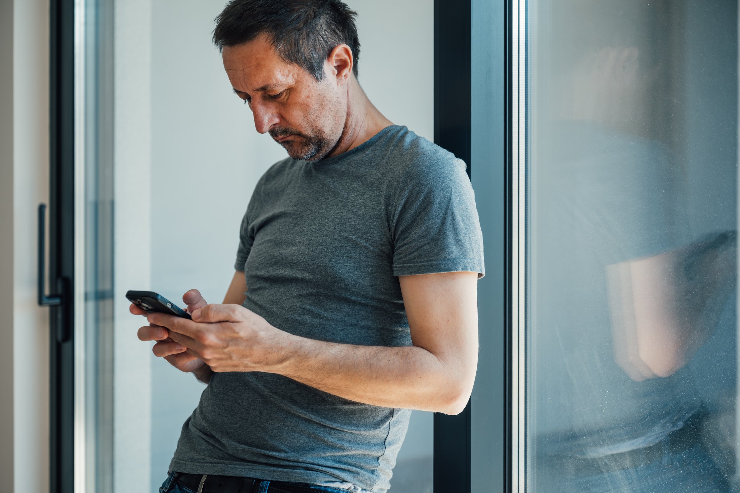 Excessive smartphone usage, man using mobile phone at home, selective focus