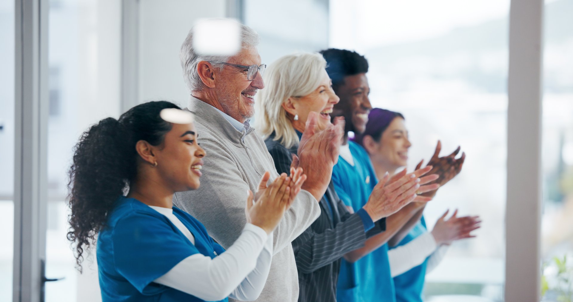 Clapping hands, board meeting and doctors in clinic with healthcare funding opportunity. Applause, discussion and medical employees with celebration for good news, achievement or goals in hospital.