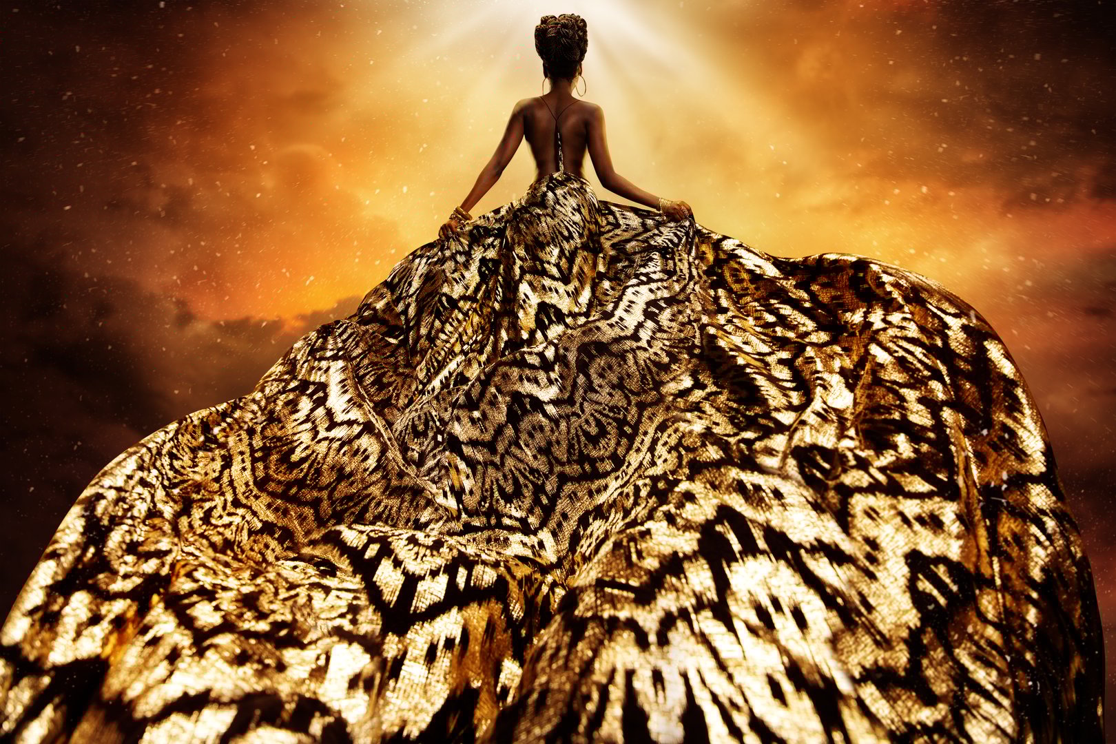 Fashion Model in Golden flying Dress looking away at Light. Afro Style Woman in Gold Long Gown fluttering on Wind rear view. Exotic Dancer with Silk Fabric over Art Fantasy Shining Night Background