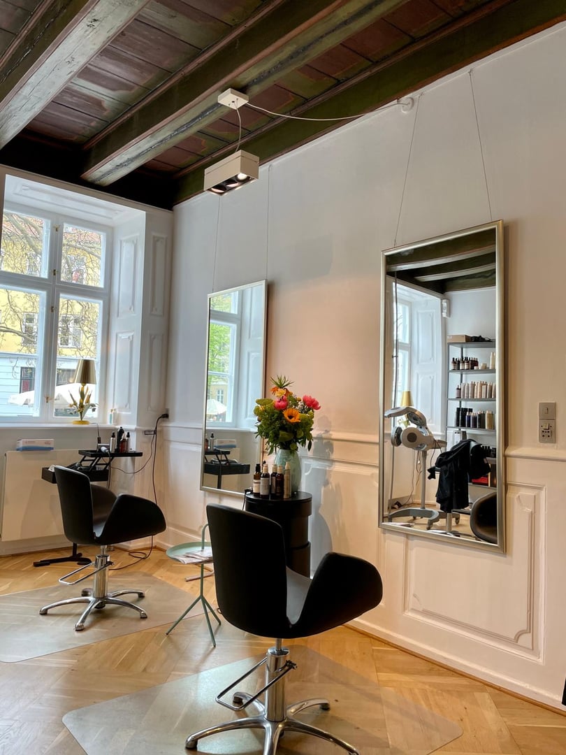 Professional hairdresser cutting girl's hair in beauty salon, closeup