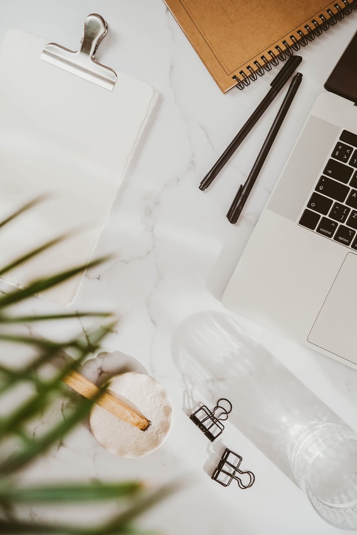 White desk office with laptop, notepads, palo santo stick and green plant flat lay. Top view. Copy space. Modern aesthetic workspace concept.