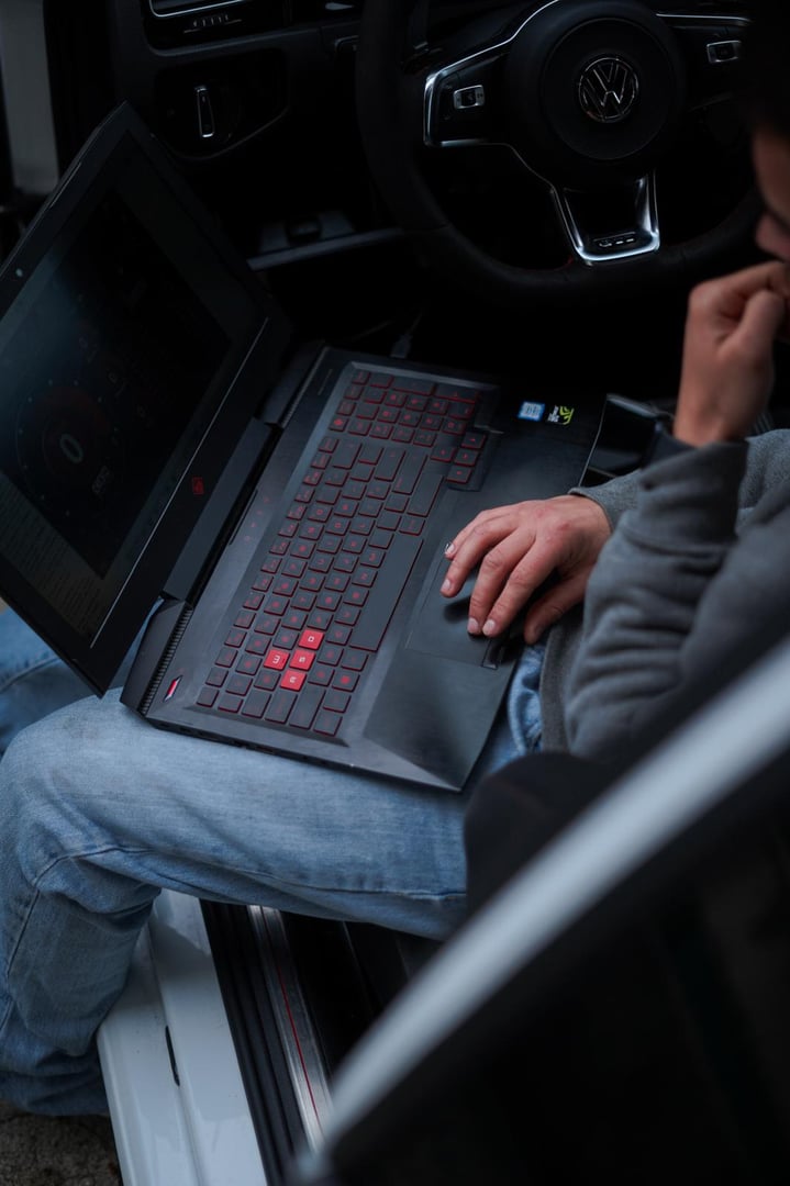 Car diagnostic concept Close up of laptop with OBD2 wireless scanner and retro car on white background 3d illustration