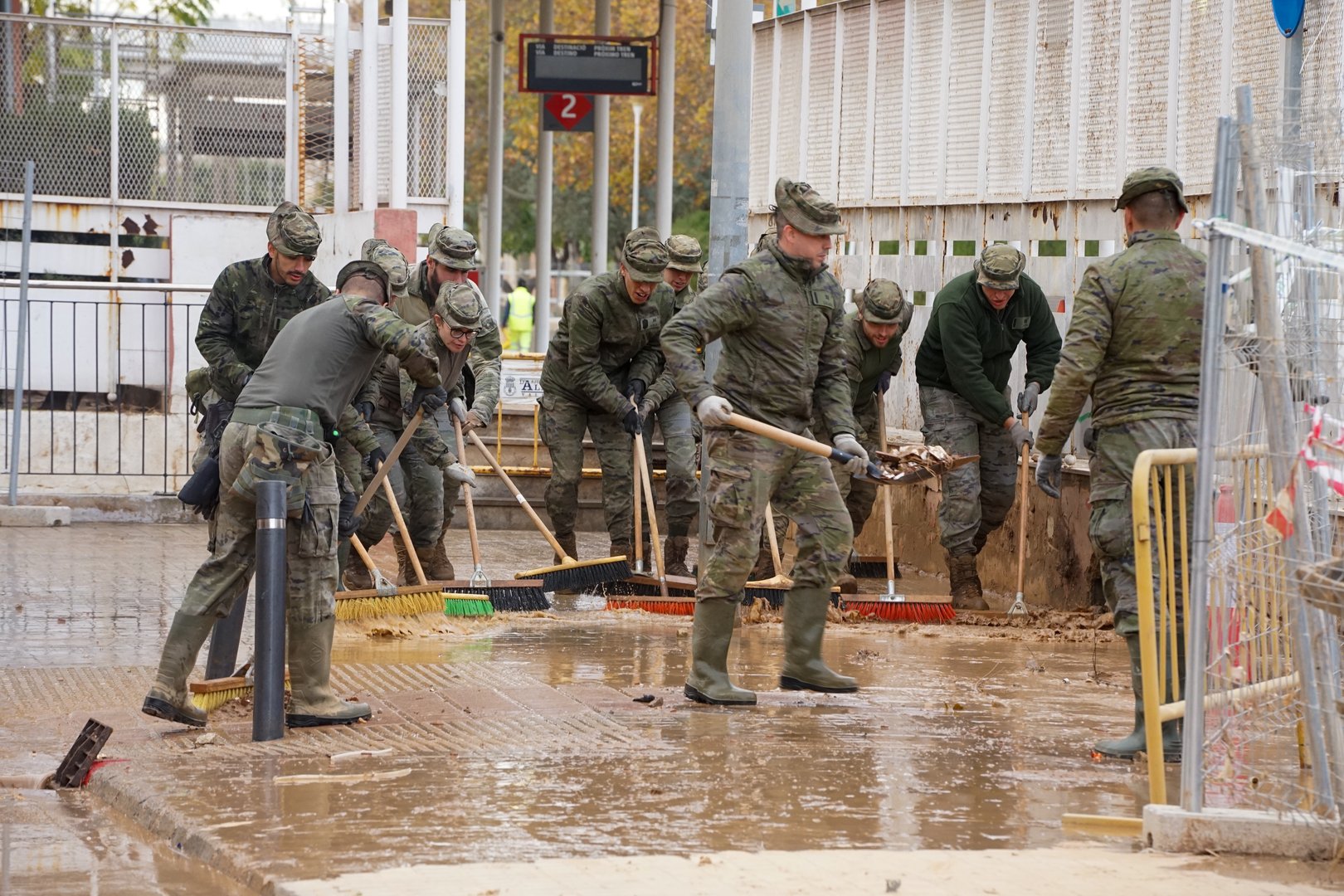 Group of soldiers with brushes, work removing mud in the streets of a town, firefighters throw water and they brush, in Aldaya, on December 11, 2024, after the floods of the Dana de Valencia