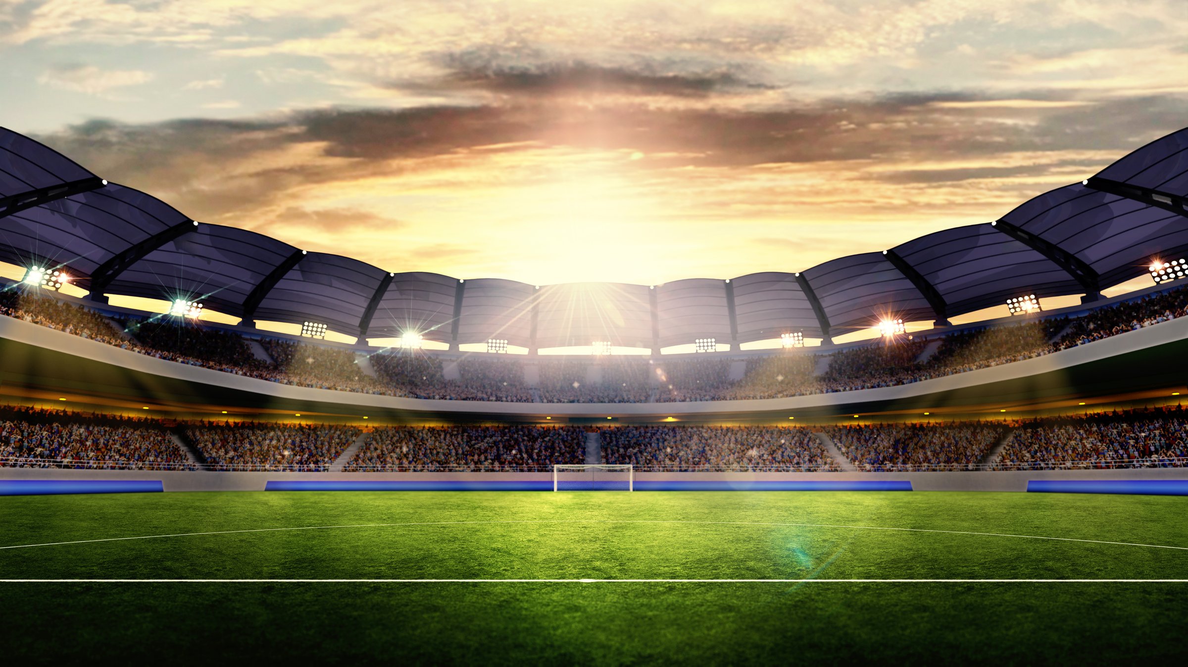 Wide-angle of large modern stadium filled with enthusiastic fans. Green football field under dramatic sky, lit by stadium lights. 3D render. Concept of sport, event, tournament, game, championship.