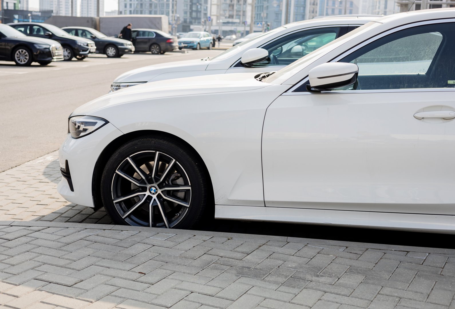 Minsk, Belarus, March 25, 2025 - Part of white luxury german BMW 330i parked on street