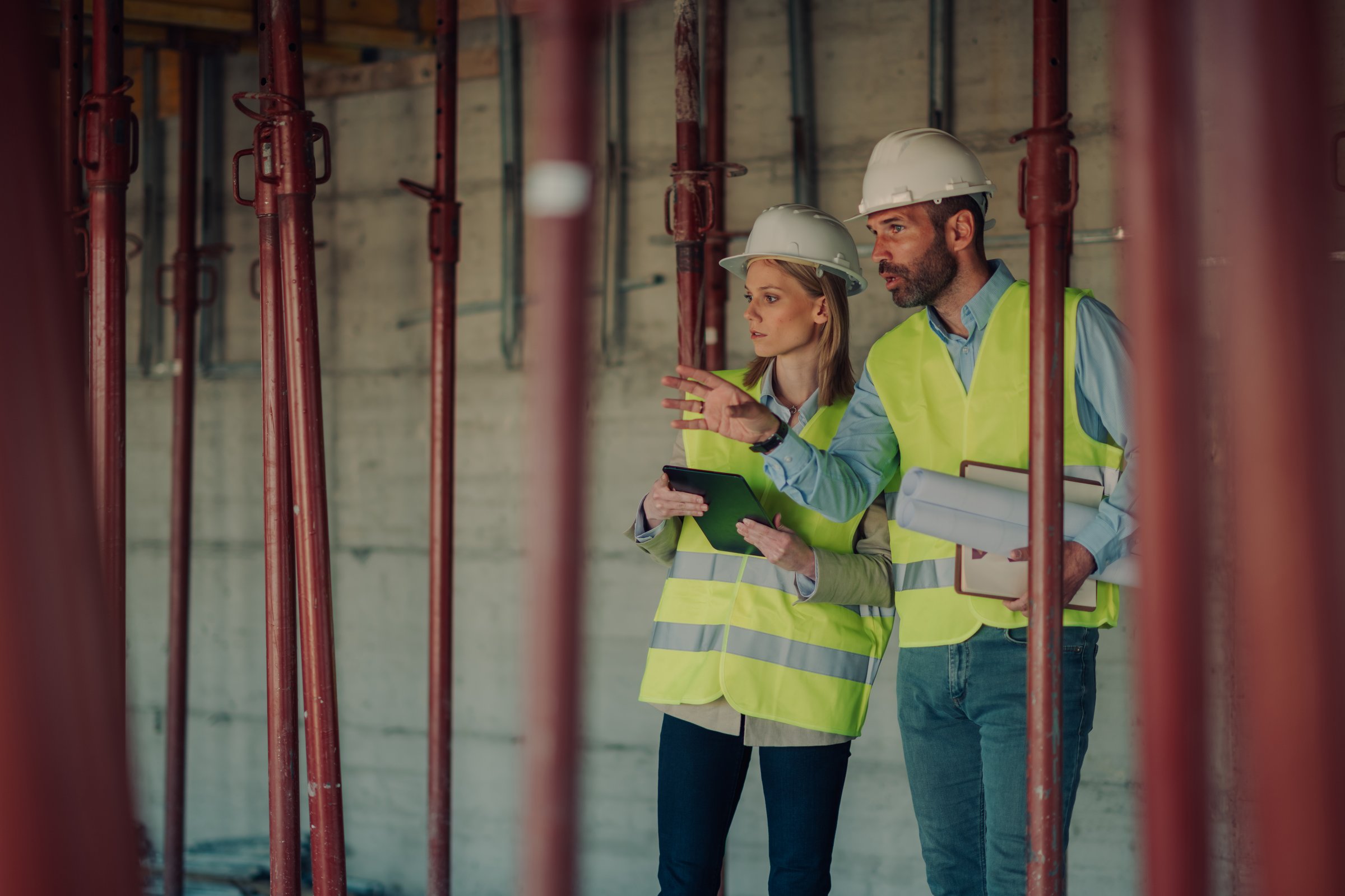 Architects reviewing blueprints and discussing progress of building project
