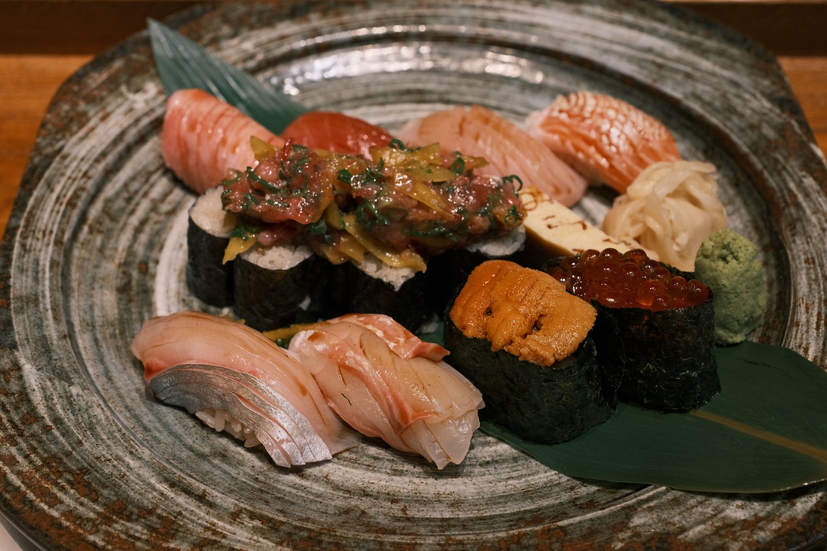 A beautifully arranged sushi platter featuring fresh nigiri and sashimi on a decorative plate with wasabi and ginger.