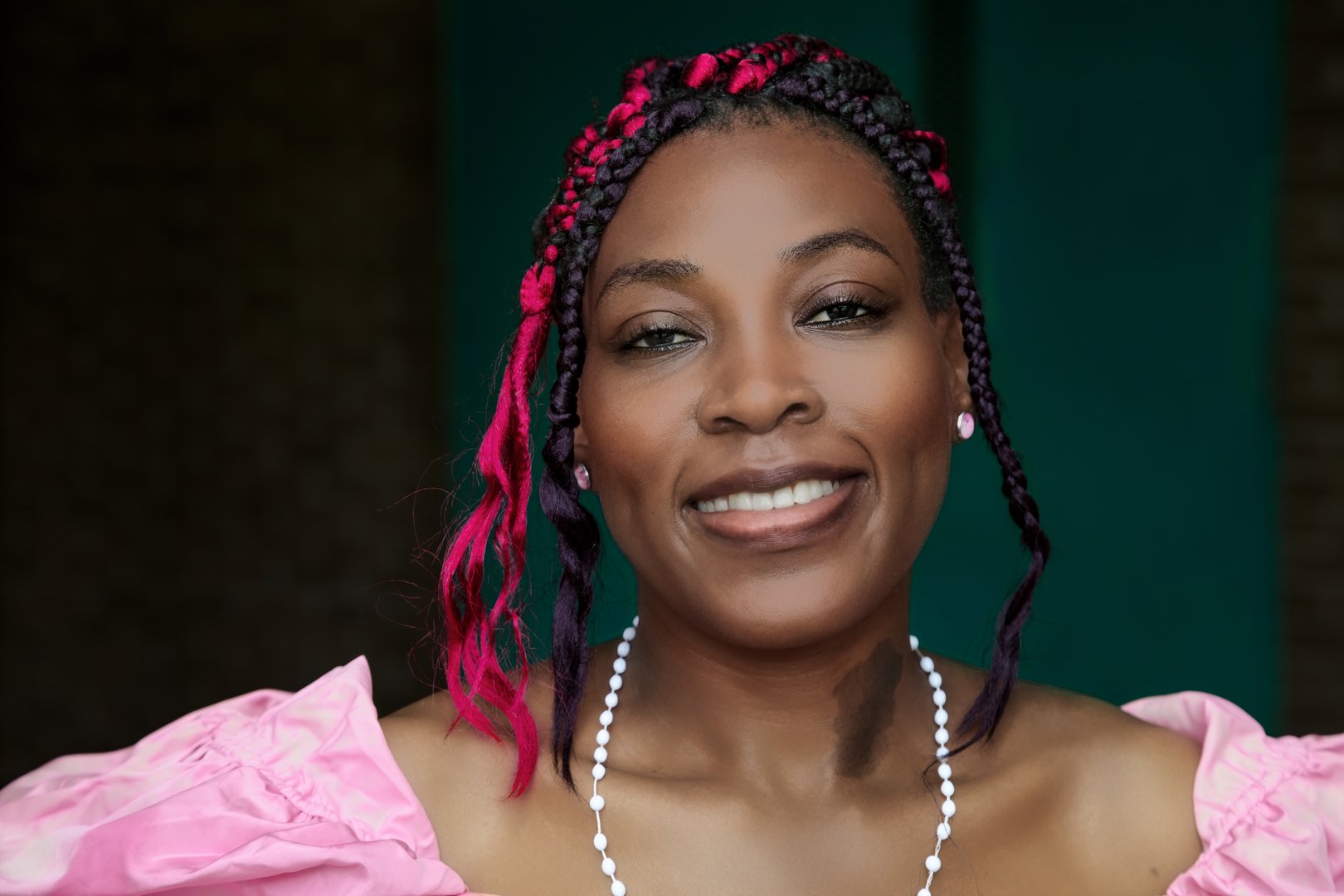 Beautiful woman in formal pink dress with protective hairstyle and pearls, perfect for luxury fashion and formal event concepts