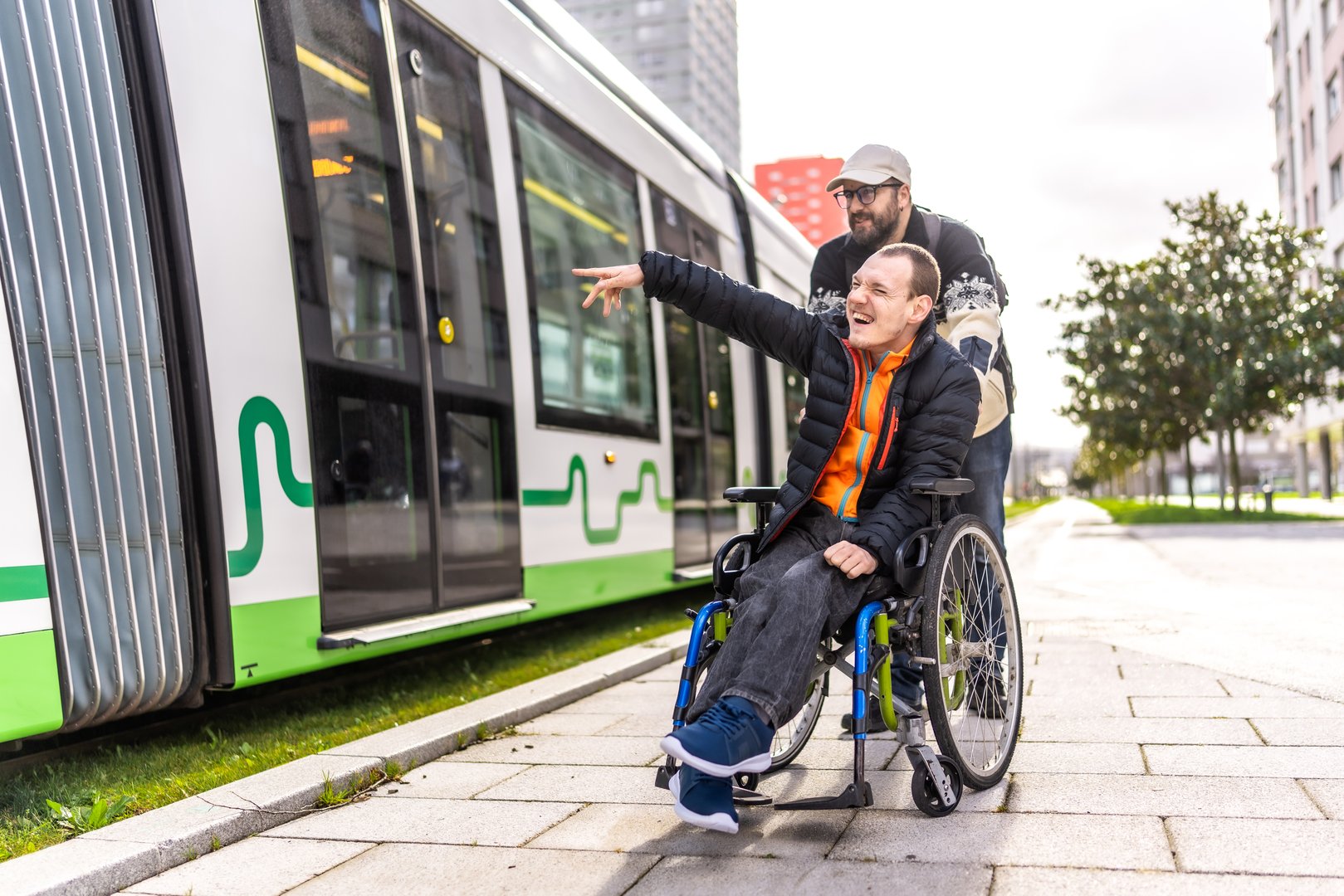 Young man with disability in a wheelchair spending the day with friend