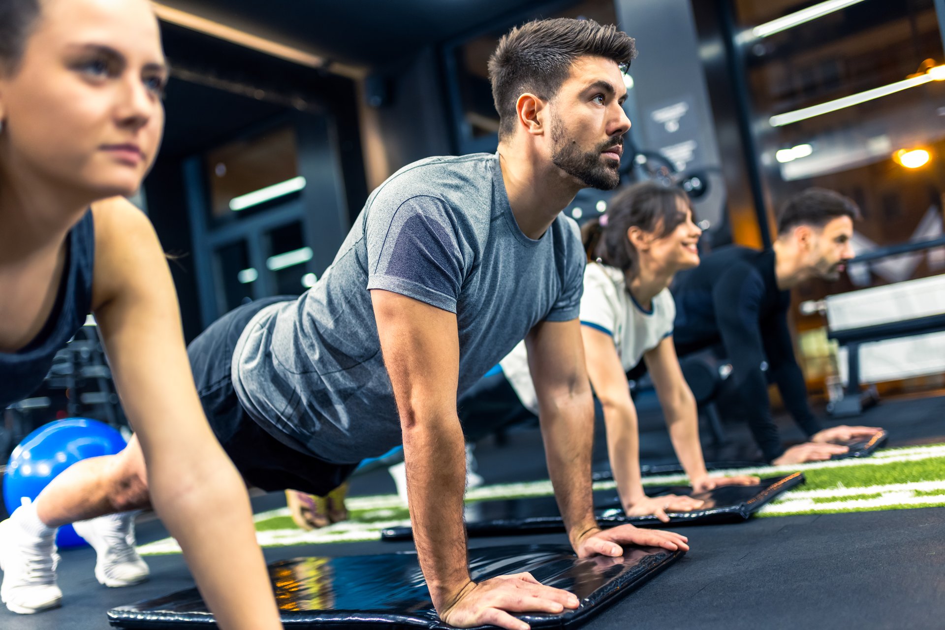 Group of sporty people doing plank exercise.