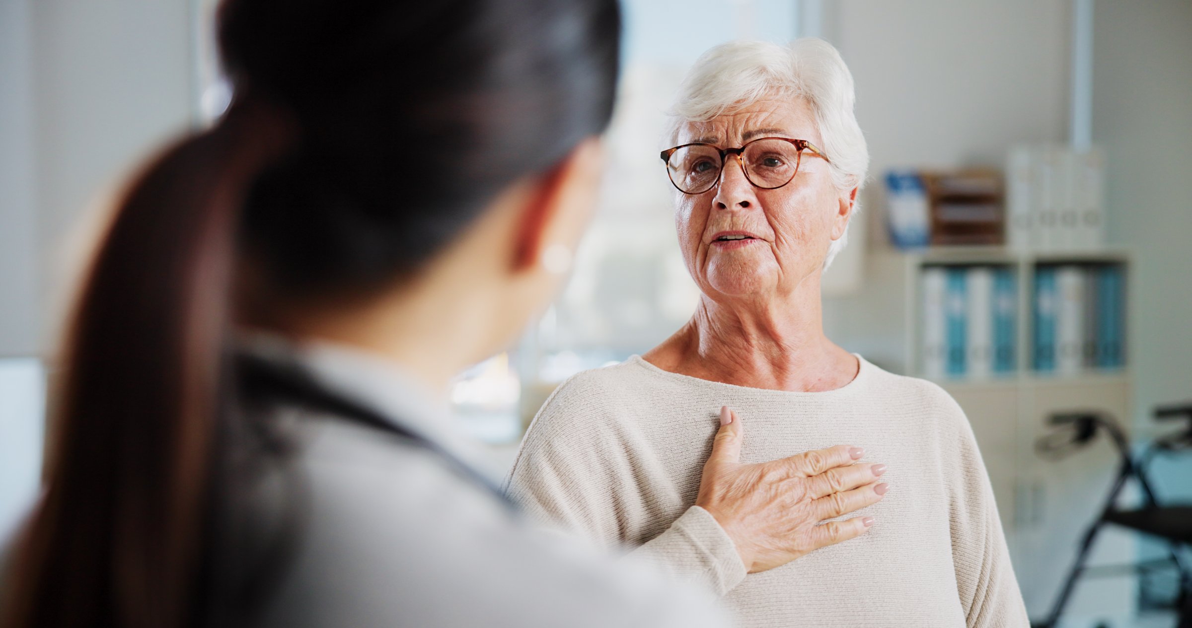 Physiotherapy, chest pain and healthcare with old woman and doctor for rehabilitation, heart arrhythmia or medical. Cardiologist, help and advice with people in clinic for healing and breathing exam