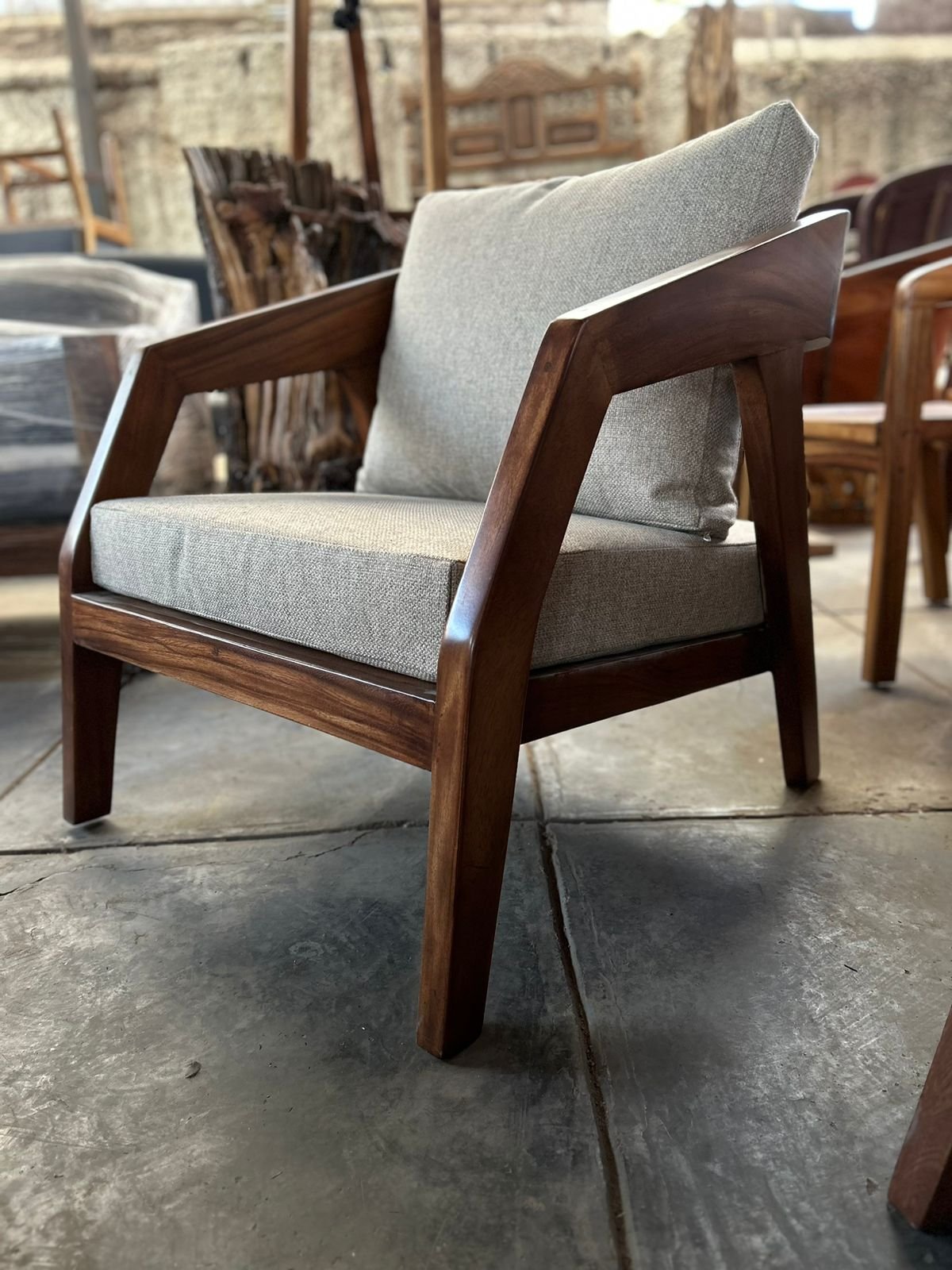 Sillón Yakuza con estructura de madera maciza, brazos facetados y tapizado en tela tipo lino gris