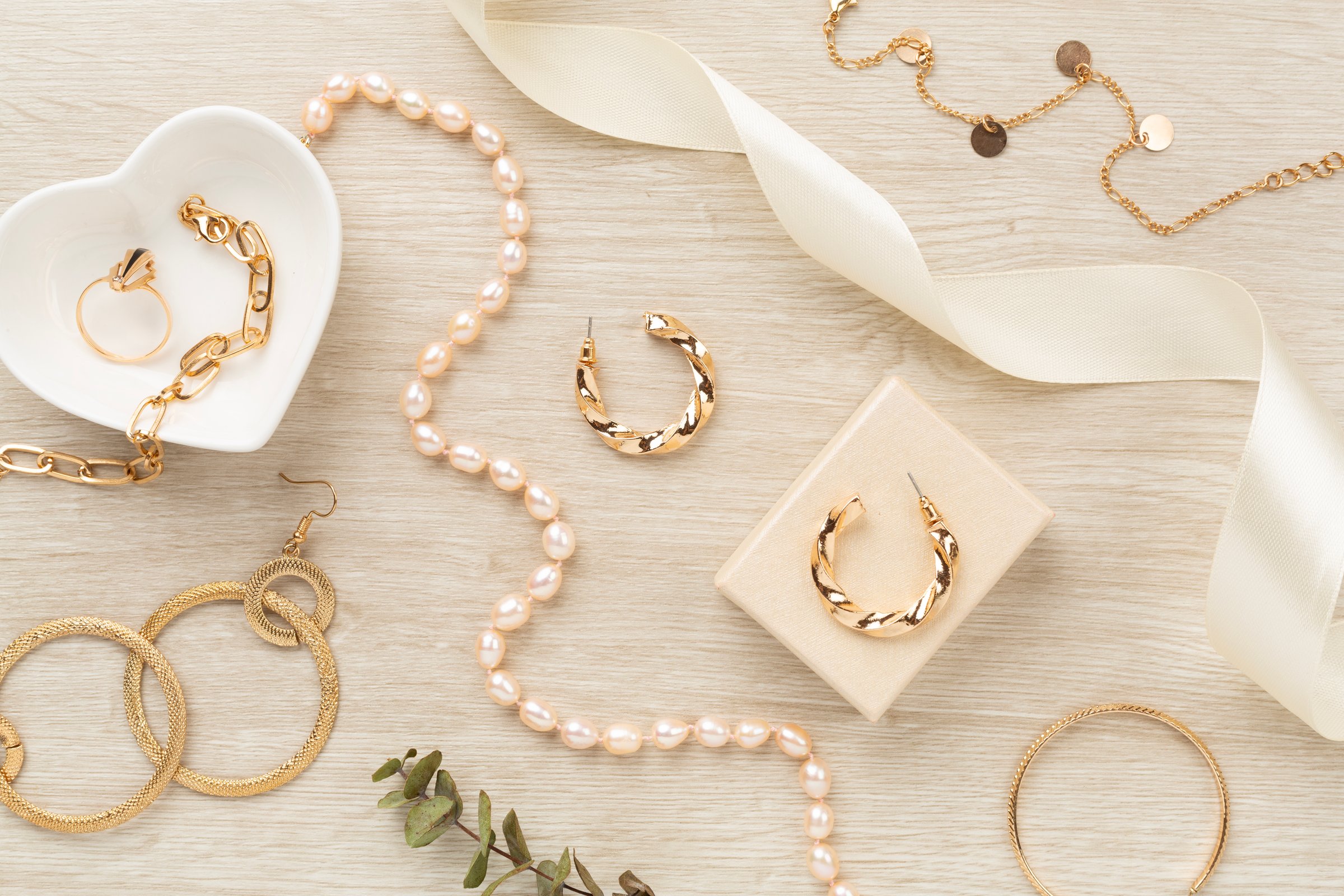 Elegant golden jewelry with decoration on wooden background, top view