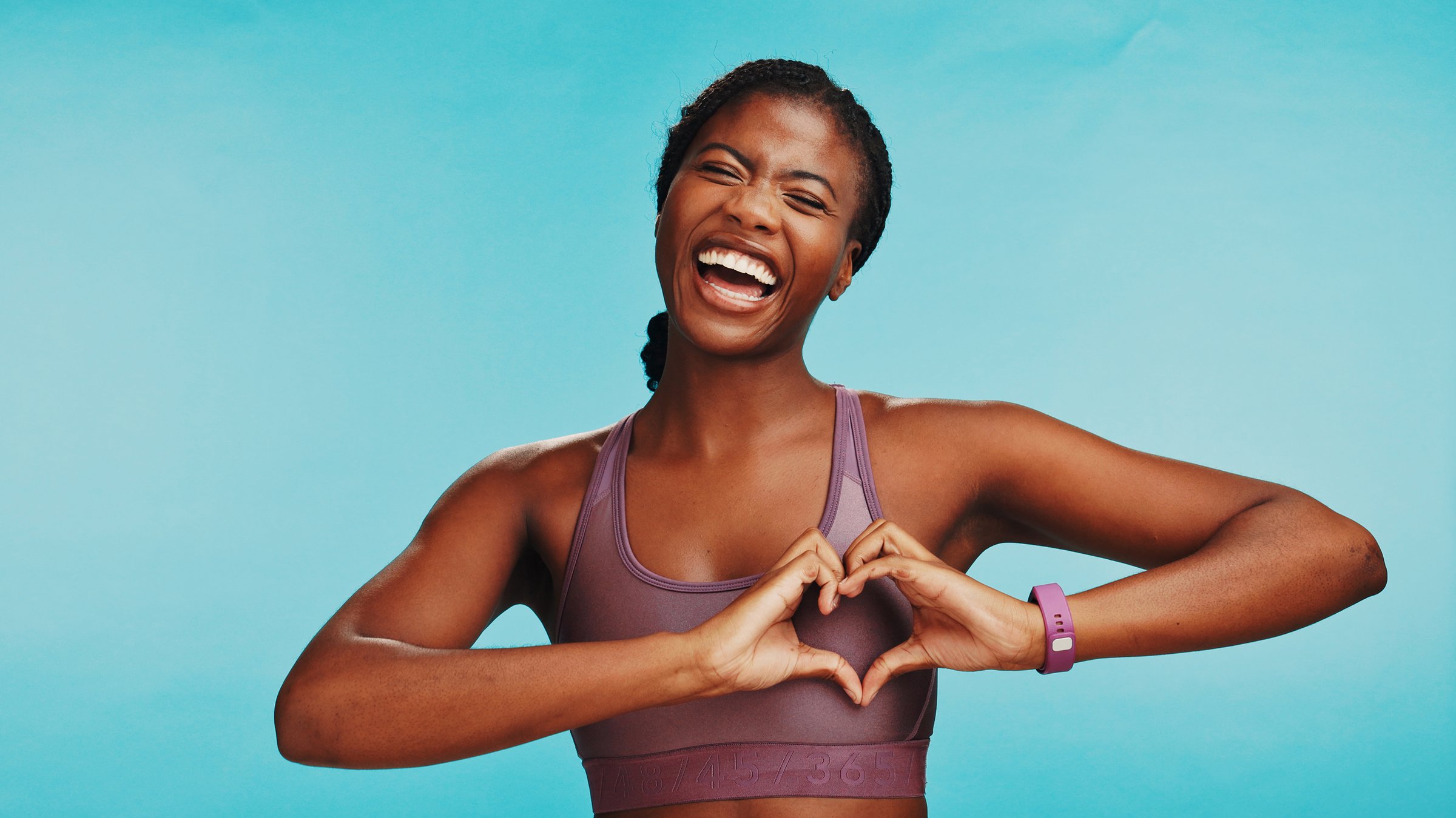 Studio, black woman and fitness with hands for heart, support and expression of love for wellness. Space, female person and excited with emoji sign for kindness, exercise or health by blue background