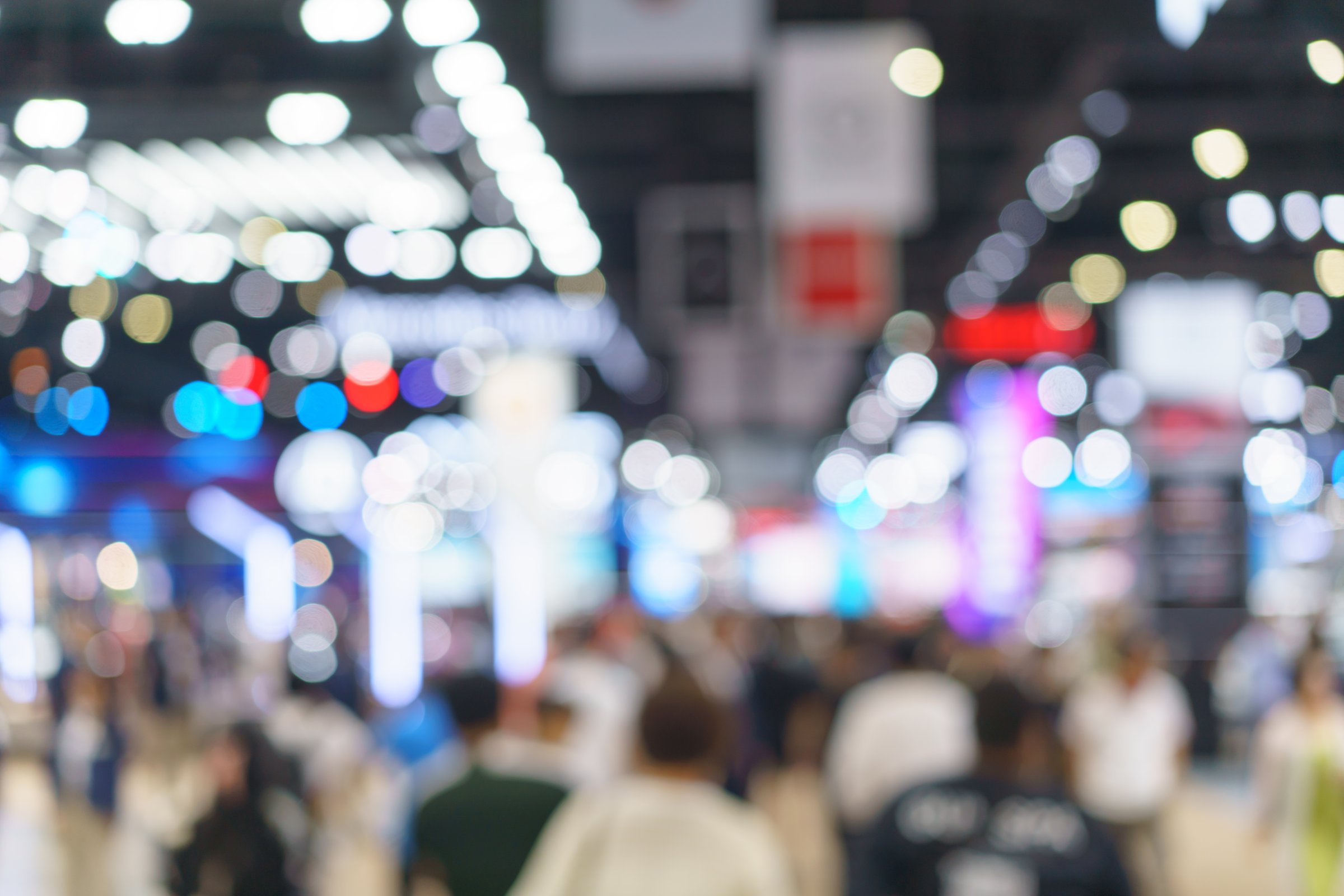 soft-focus look at a bustling motor show packed with visitors and dazzling lights, highlighting energy, excitement, and automotive displays.