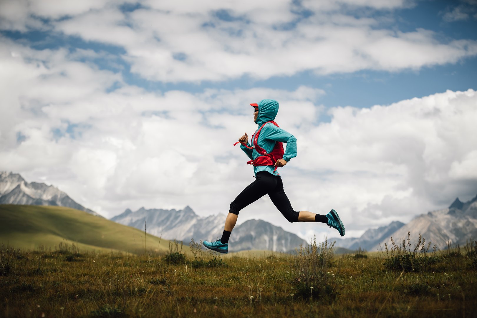 Fitness woman trail runner running in grassland