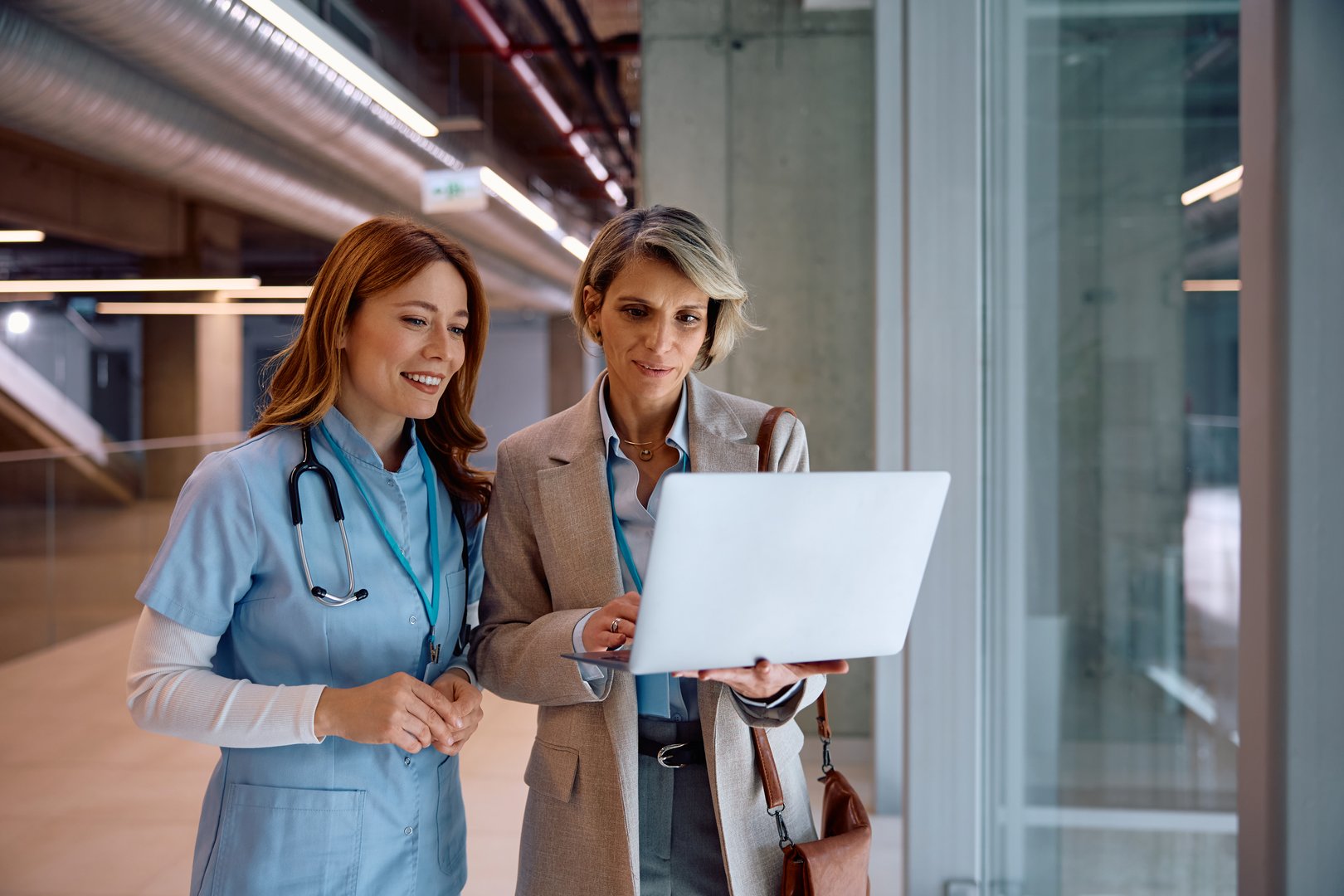 Happy nurse and businesswoman working on a computer at medical clinic.