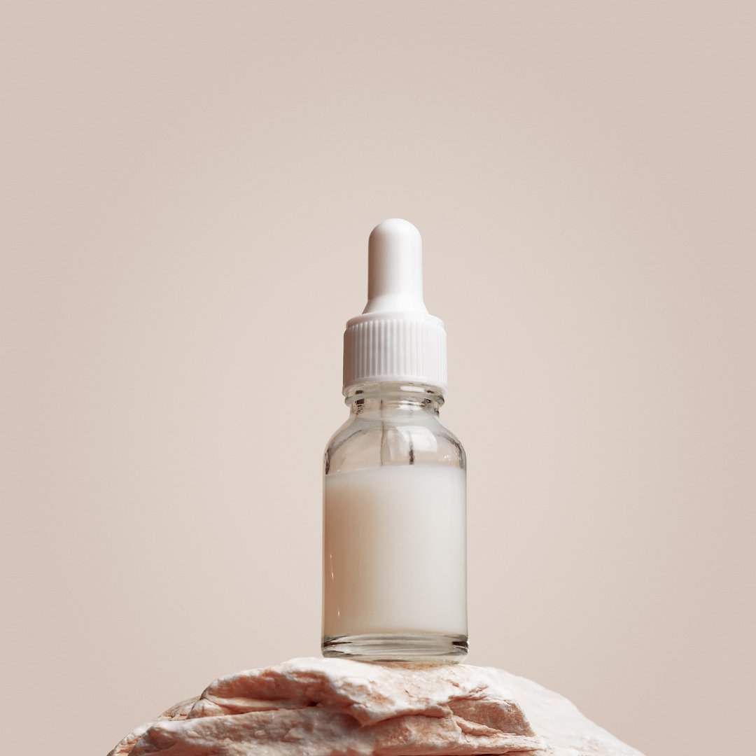 Glass dropper bottle with white liquid essence, serum, cream on stand from natural stone, minimal beige gradient background. Natural Cosmetic, monochrome aesthetic mockup cosmetic product for skincare