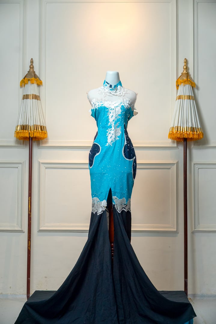Elegant turquoise and navy gown with white floral lace details, high collar, and long train, displayed on mannequin in a classic setting, perfect for wedding or evening events.