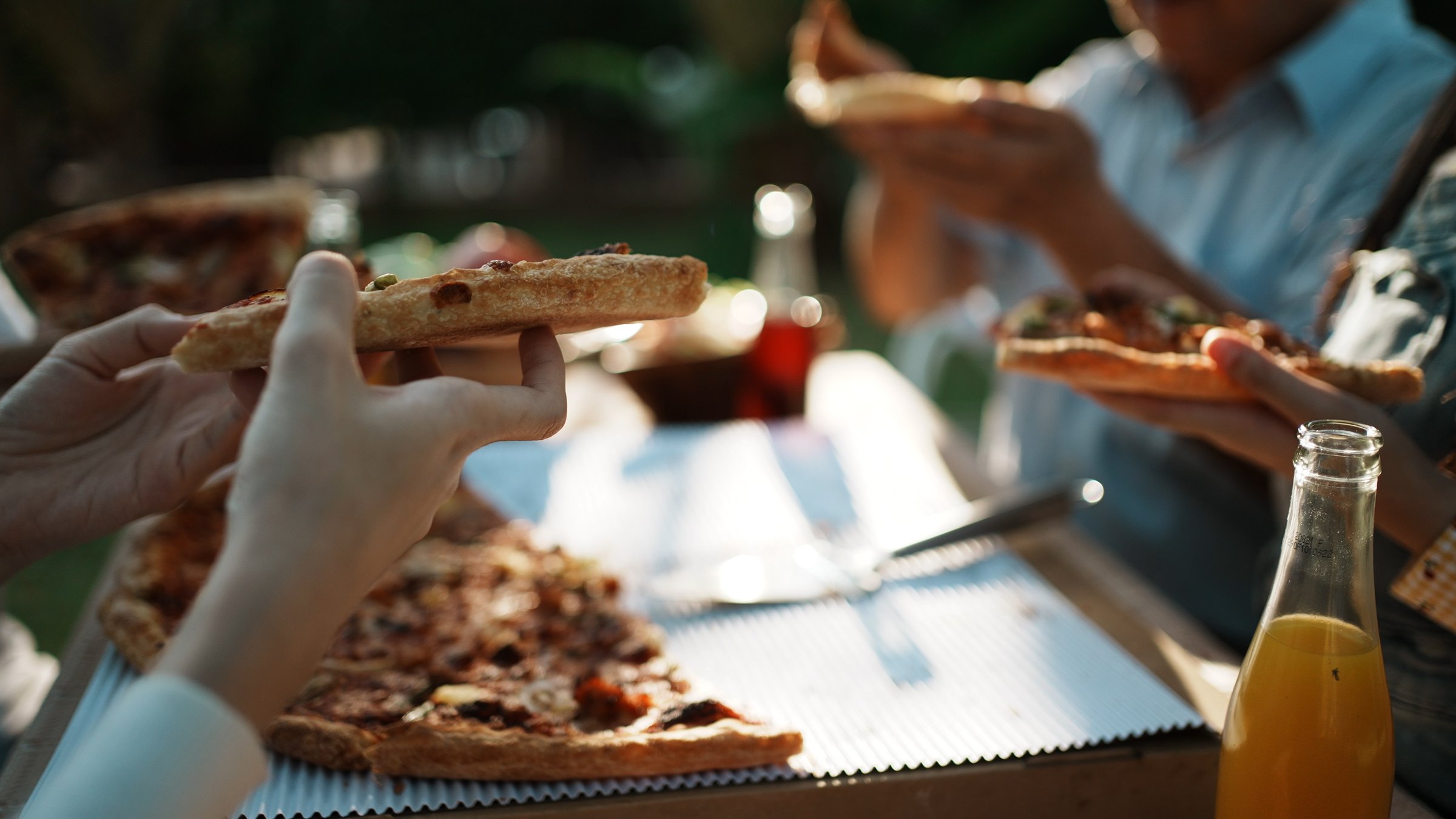 Asian family celebration pizza party outside in the backyard. Happy family having festive dinner or barbecue party in their garden in summer Holidays and people concept. Family lifestyle.
