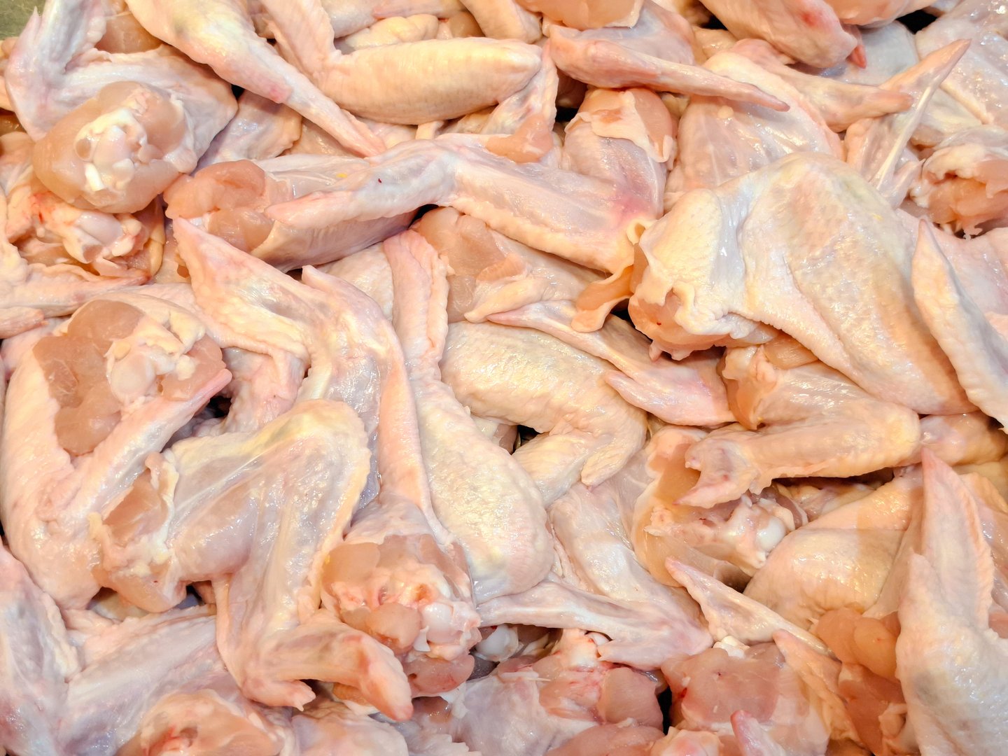 Pile of raw chicken wings. Abundant fresh chicken wings