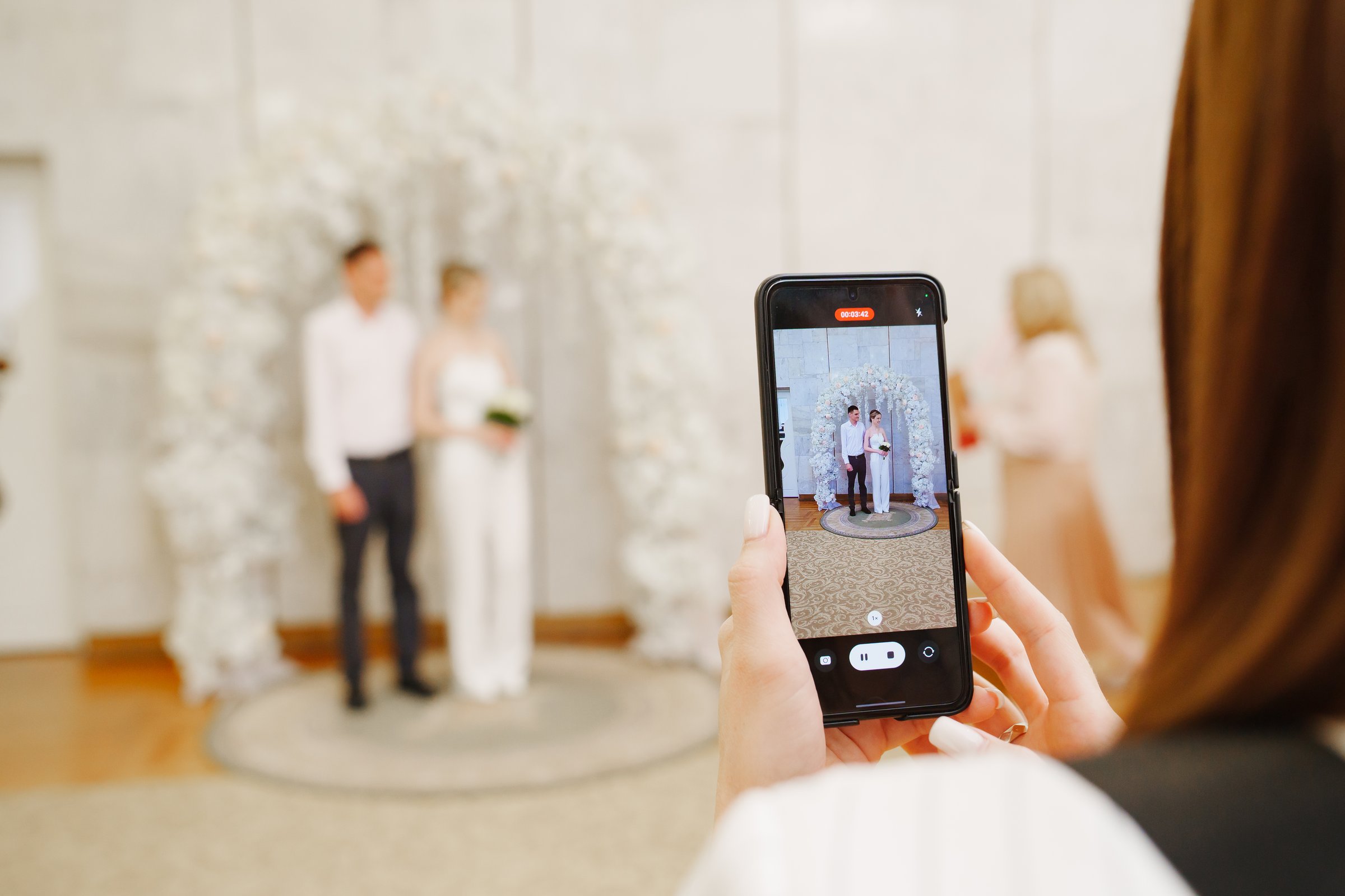 A young woman is filming a wedding ceremony at the registry office.