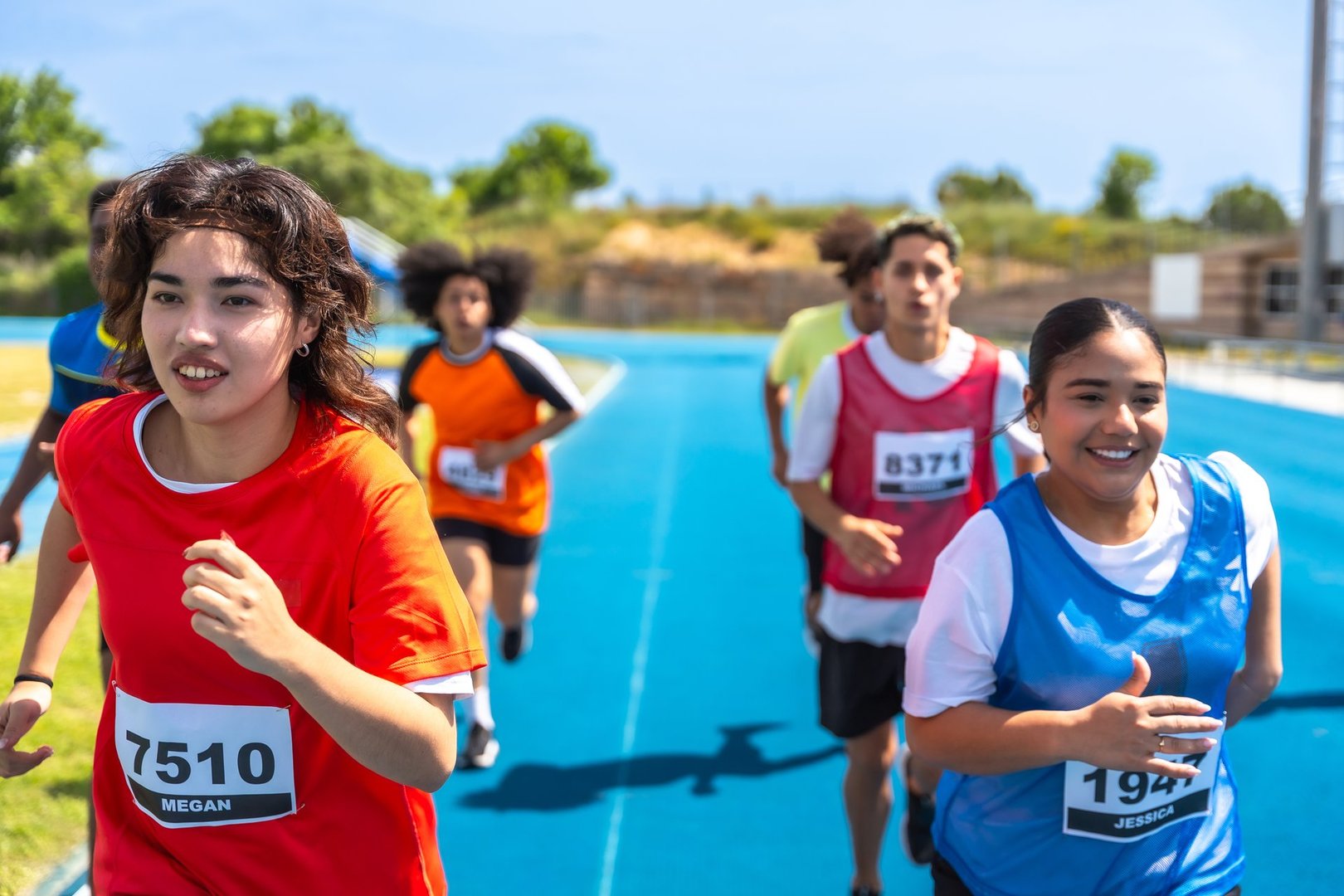 Teen athletes competing in race with custom team uniforms