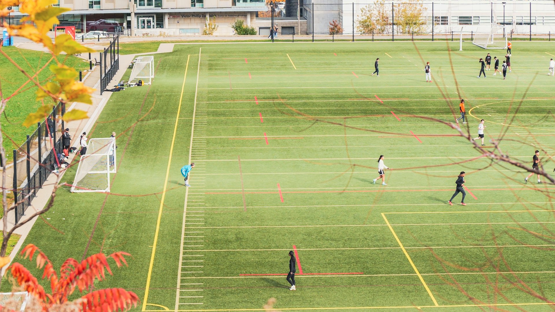 Montreal, Quebec Canada - Oct 27 2024: McGill university Students playing soccer on a university campus with modern buildings in the background.