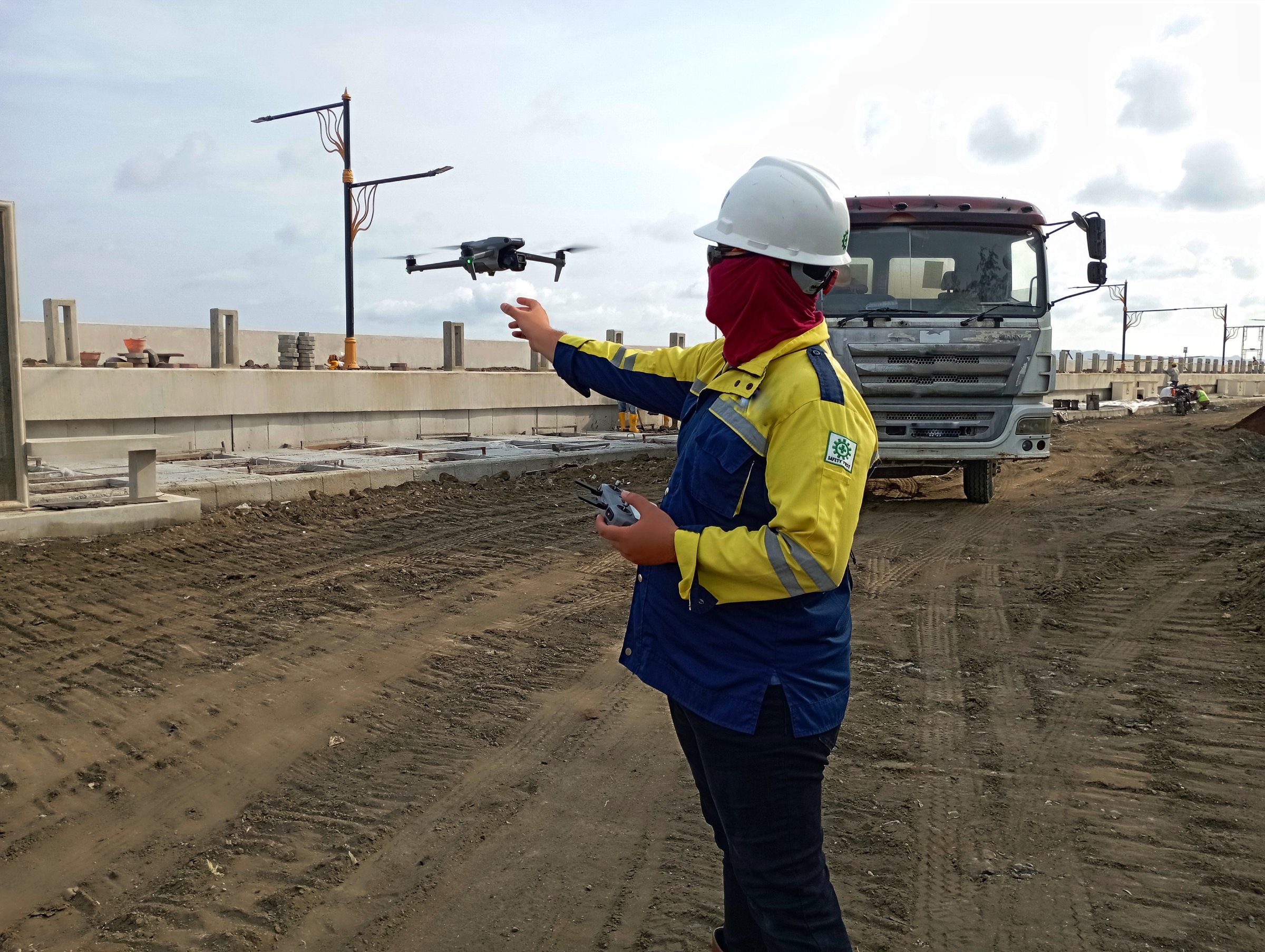 Cilacap, Indonesia October 14, 2024: Specialist Engineers Pilot Drones on Construction Sites. Architectural Engineers and Safety Engineering Inspectors Fly Drones on Construction Sites